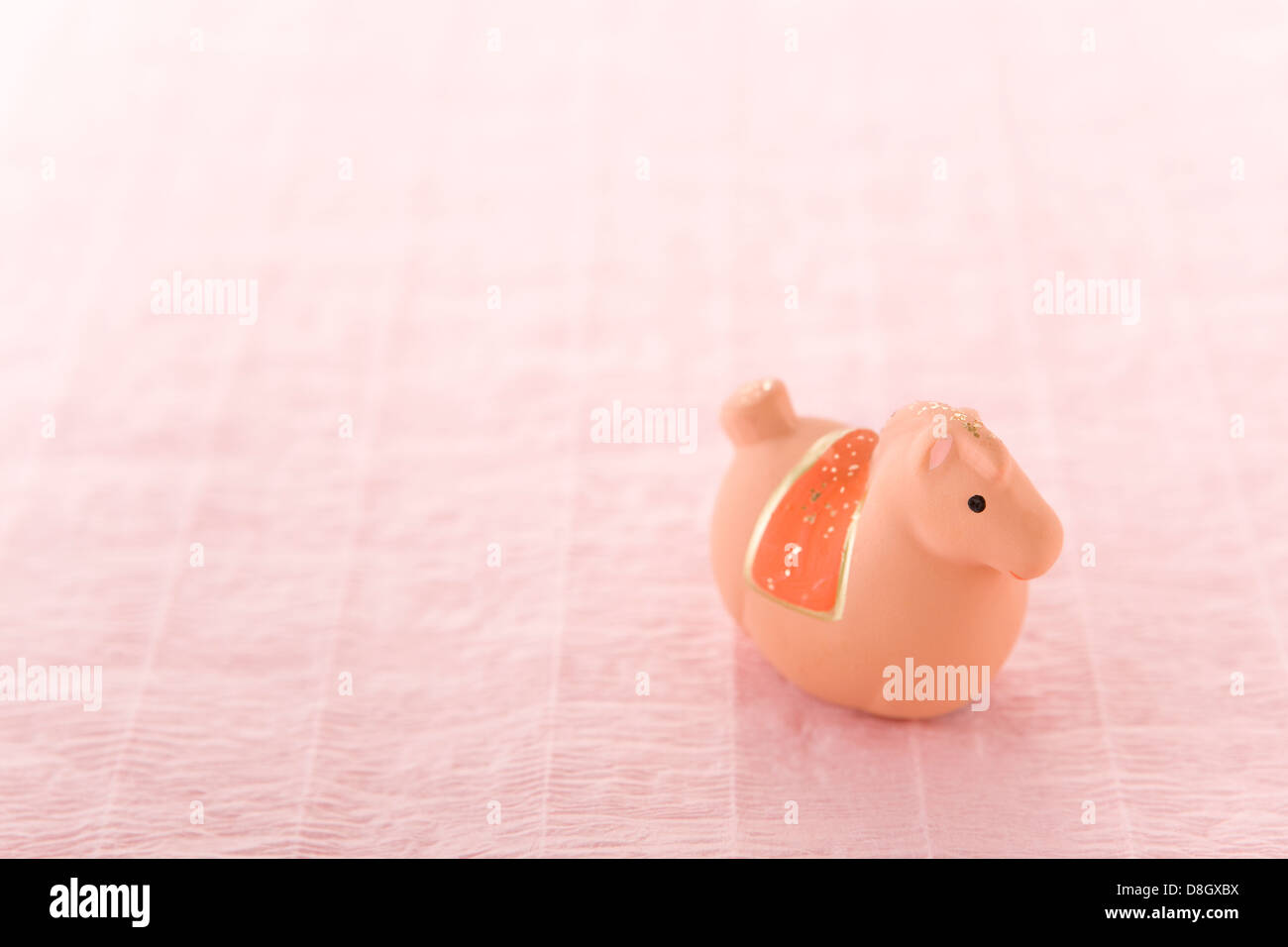 Spielzeugpferd auf rosa Papier Stockfoto