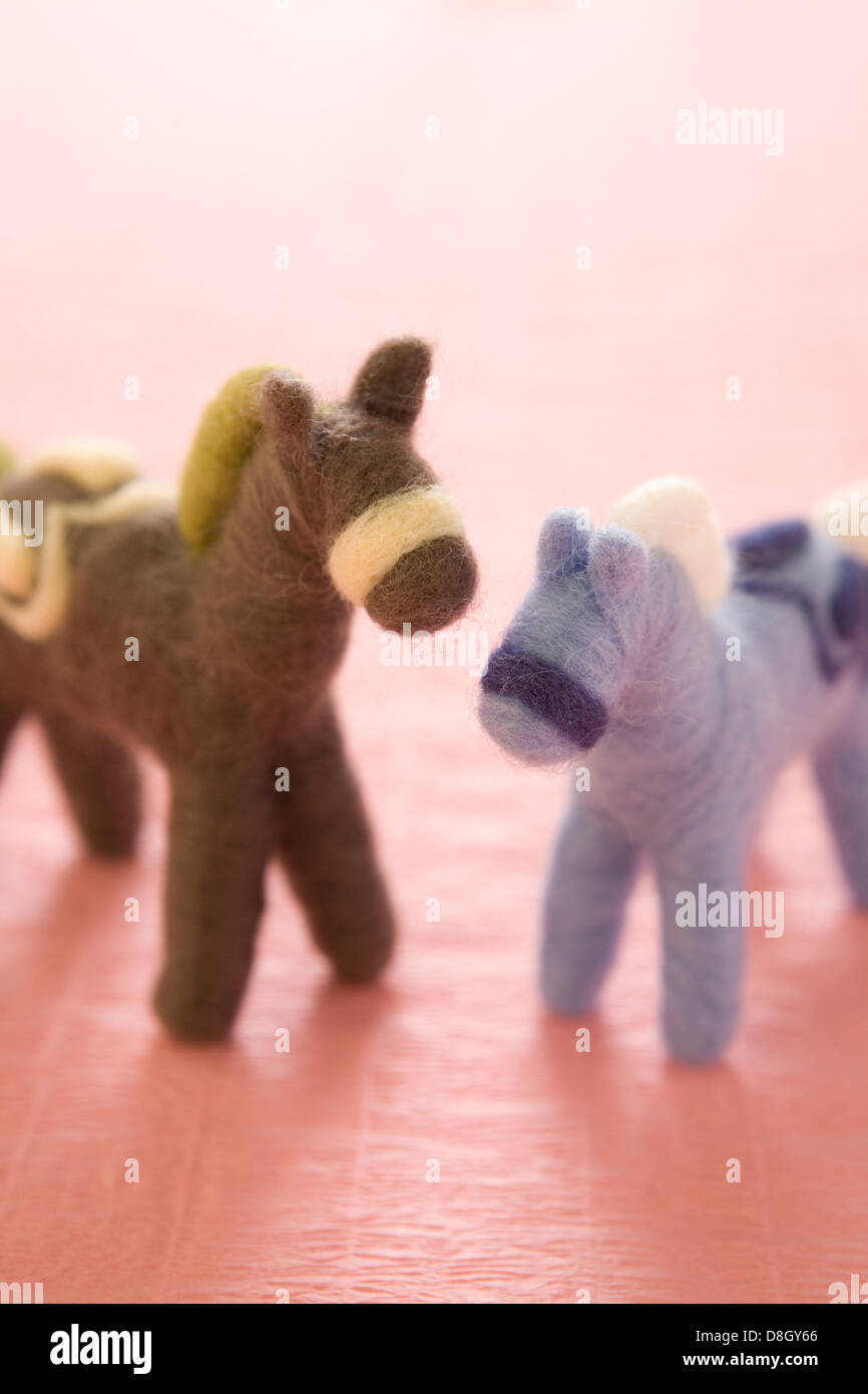 Zwei fühlte Spielzeug Pferde auf rosa Papier Stockfoto