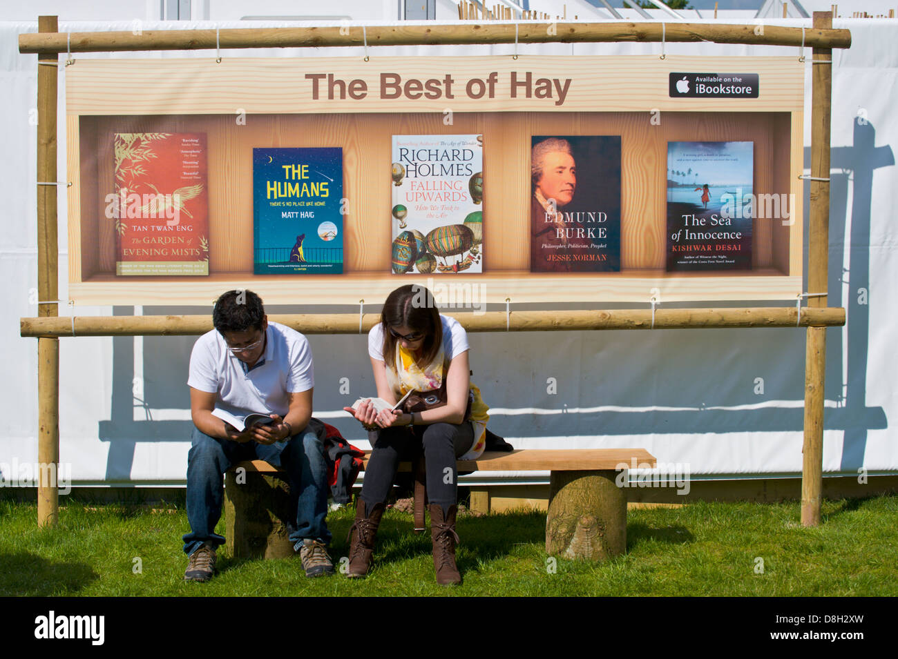 Paar Bücher lesen saß auf der Bank im Sonnenschein Hay Festival 2013 Hay on Wye Powys Wales UK Stockfoto