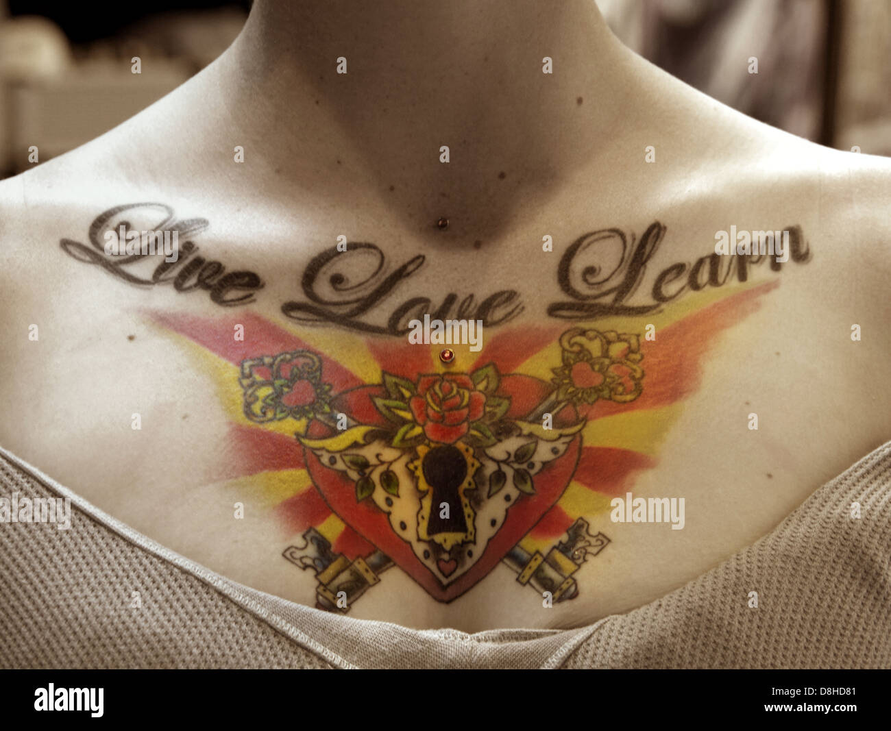 Ein Womans Brust weiterleben Sie Liebe lernen Tattoo mit einem Schlüsselloch Herzen Stockfoto