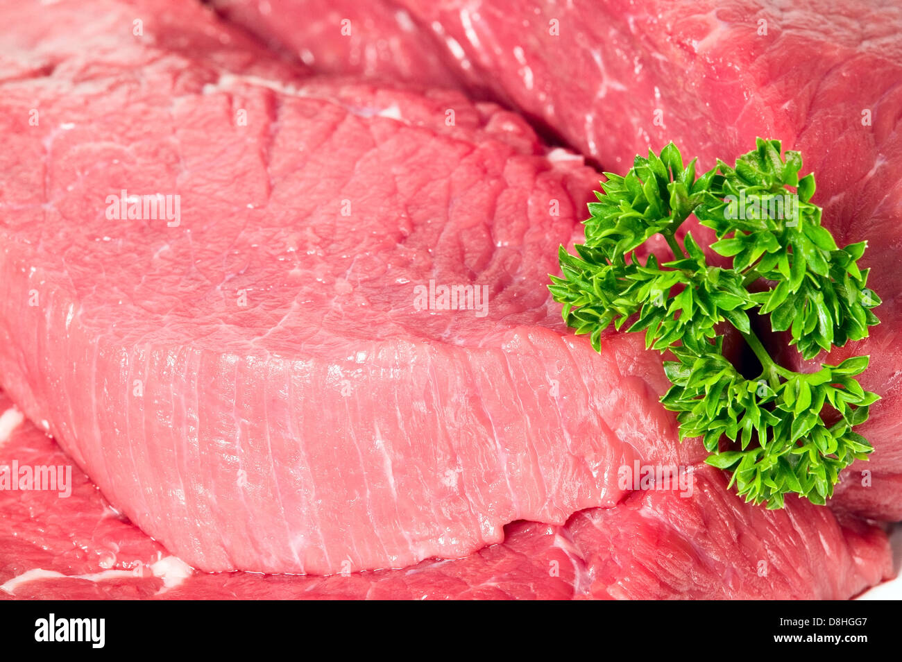 Rohstoffe, die in Scheiben geschnittenen Fleisch mit Petersiliengrün, Hintergrund Stockfoto