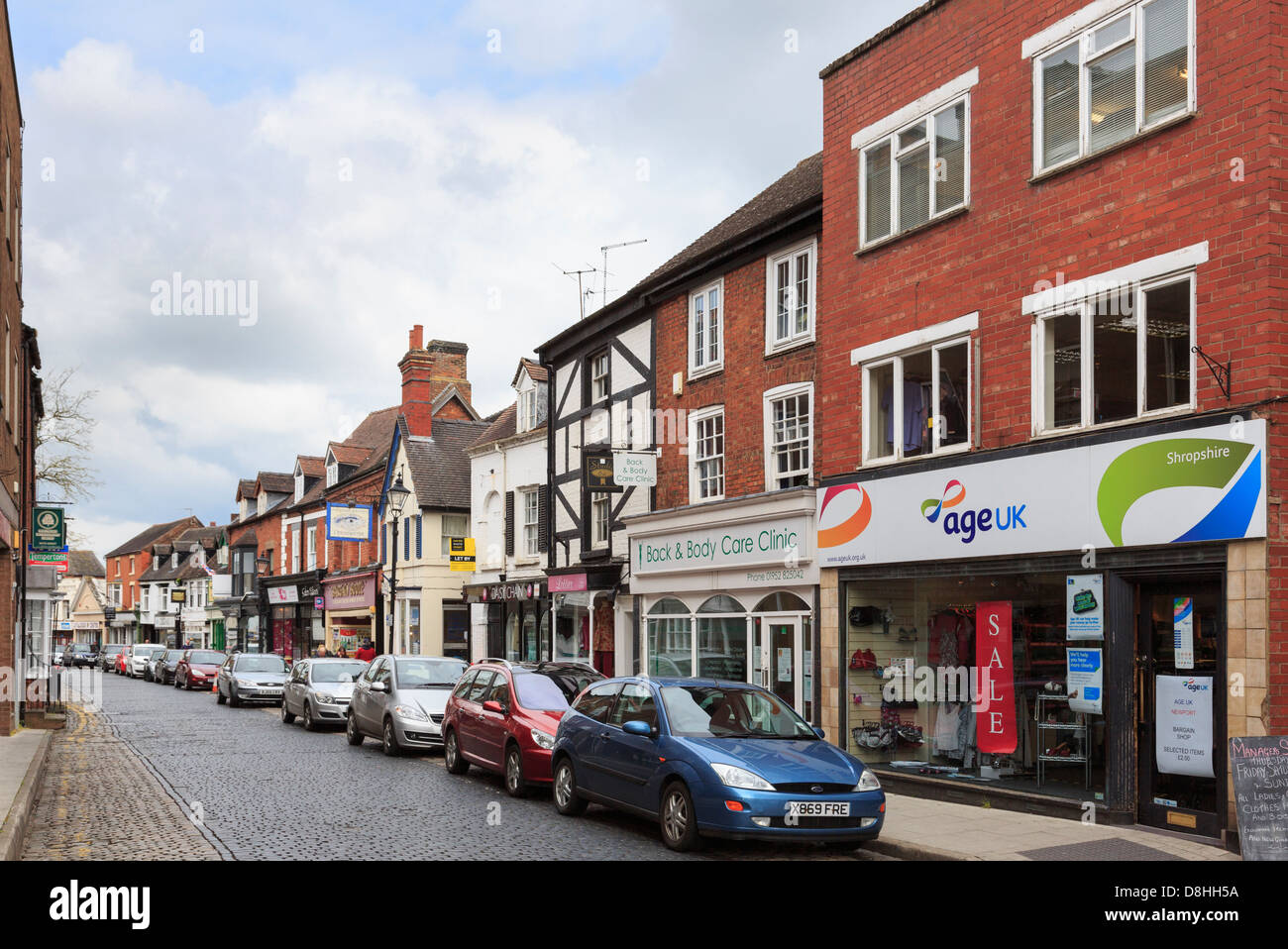 Stadtzentrum Geschäfte und Unternehmen, die mit dem Wagen auf der Straße geparkt auf gepflasterten St. Mary's Street, Newport, Shropshire, West Midlands, England, Großbritannien Stockfoto