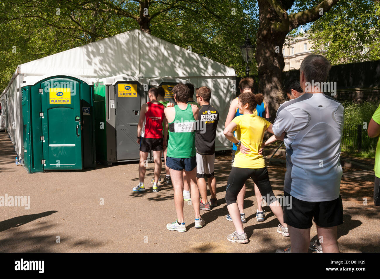 Läufer, die Schlange für die mobilen Toiletten an der BUPA London 10k laufen 2013 Stockfoto