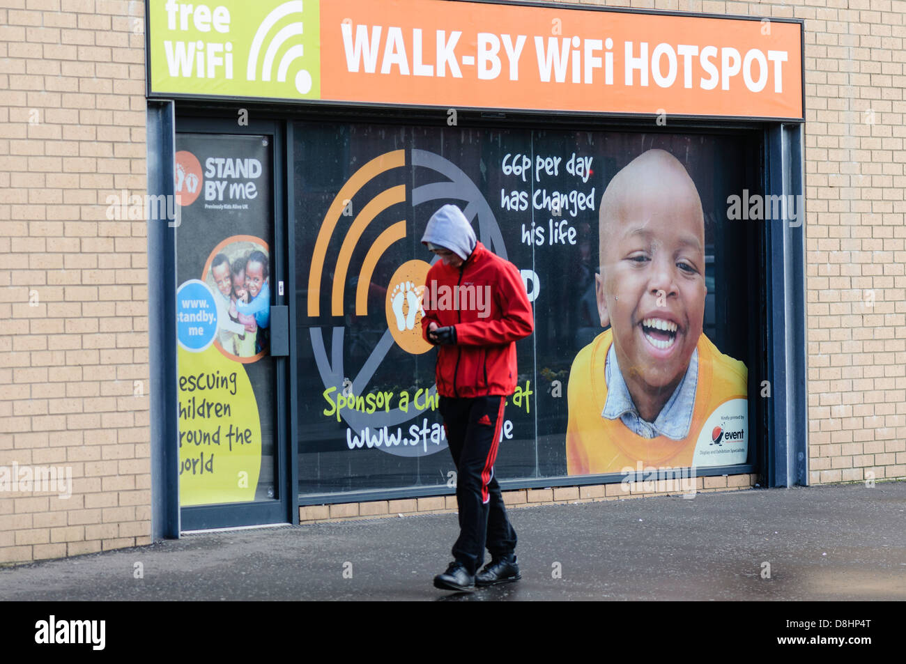Teenager geht vorbei an einem Spaziergang durch WiFi-Hotspot mit seinem smartphone Stockfoto