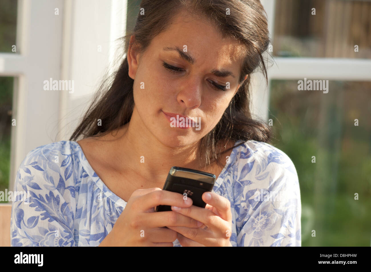 multikulturelle Frau auf Blackberry-Telefon Stockfoto