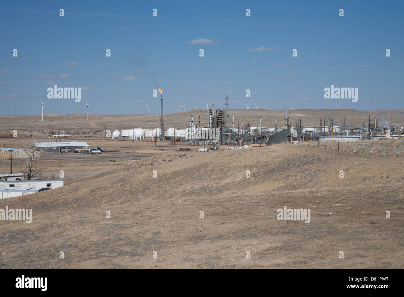 Ironisch Energie Foto mit Windmühlen im Hintergrund und ein Öl / Gas Raffinerie- und Gastechnik flare im Vordergrund. Stockfoto