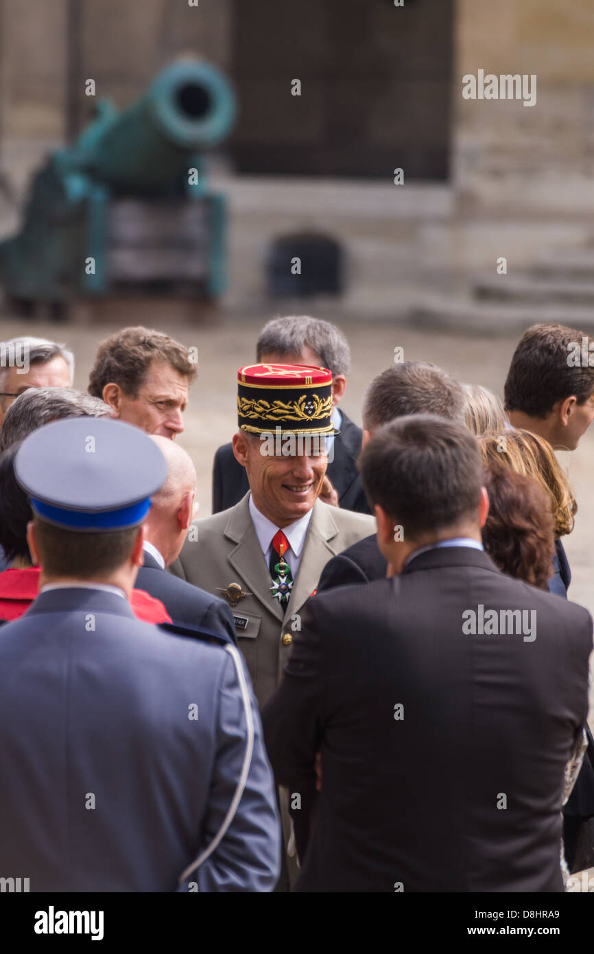 Les Invalides, Paris, Frankreich. Ein hoher Offizier engagiert sich in einem Gespräch mit einer Delegation aus Polen. Kanone im Hintergrund. Stockfoto