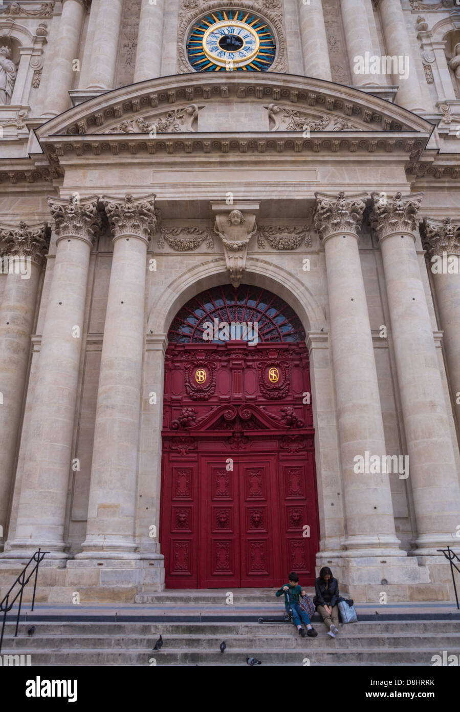 Paris, Frankreich. Mutter und Sohn sitzen auf der Treppe der Kirche Saint-Paul-Saint-Louis im Marais-Viertel. Stockfoto