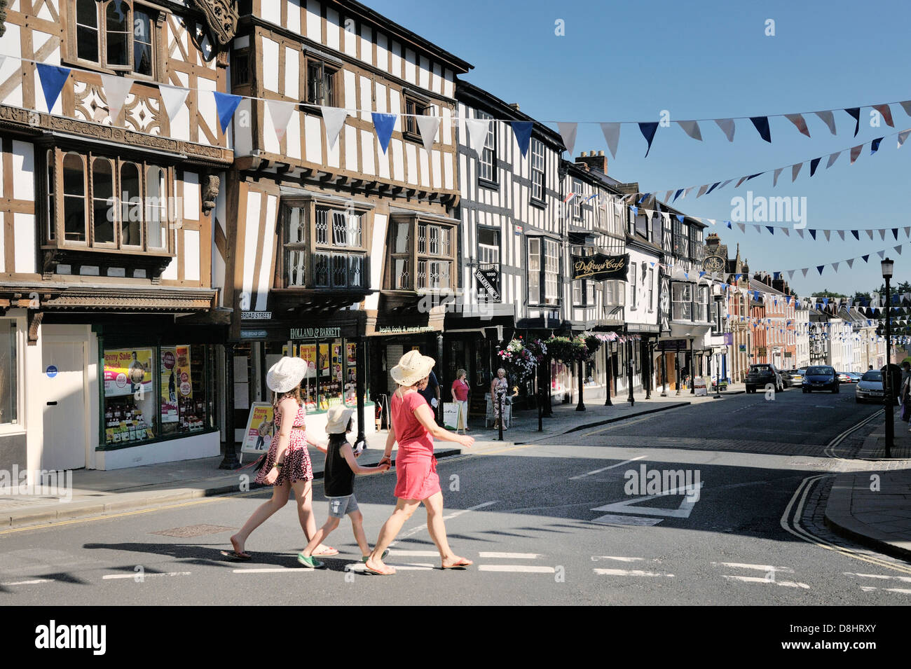Mittelalterliche Stadt, Häuser und Geschäfte von Ludlow, Shropshire, England. Zeigen Sie nach unten Broad Street aus dem Butter Kreuz auf High Street an Stockfoto