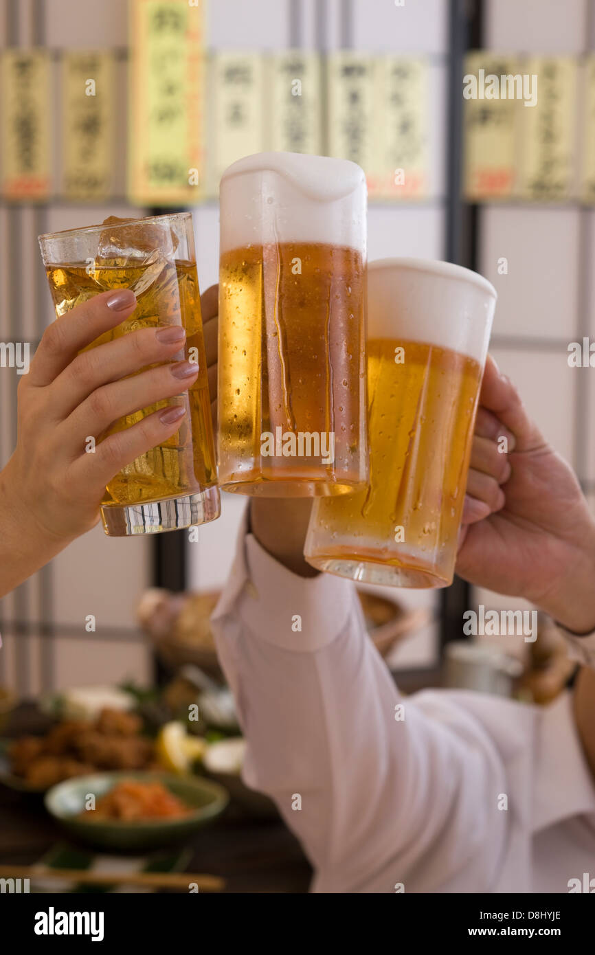 Drei Leute mit Bier und Chu-Hallo in Izakaya Toasten Stockfoto