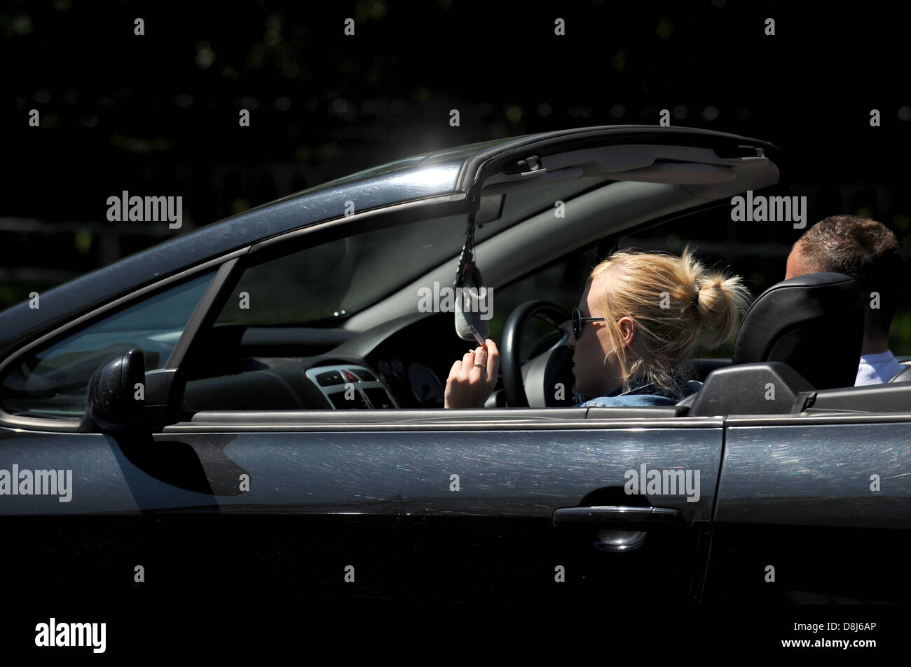 Junge Frau raucht eine Zigarette in einem offenen oberen Wagen Auto-UK Stockfoto