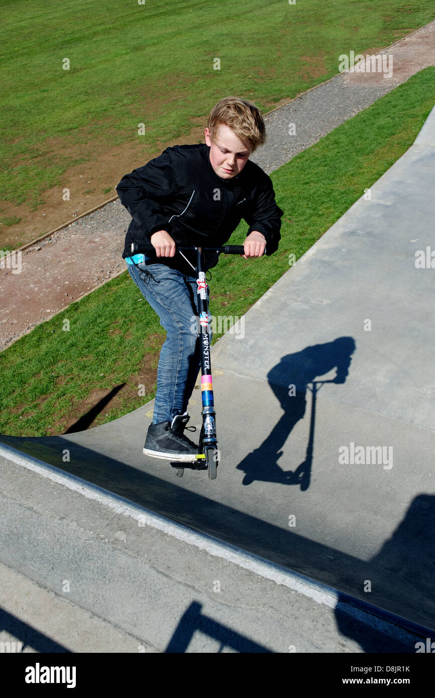 Ein Junge in die Luft auf seinem Roller Stockfoto