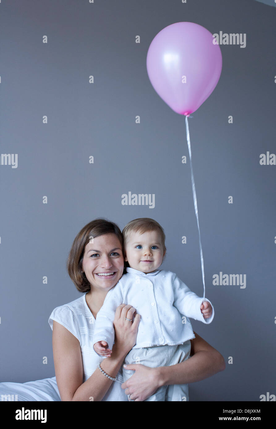 Mutter und Baby, Baby halten Ballon Stockfoto