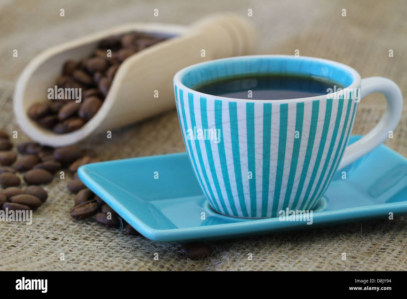 Schwarzer Kaffee im gestreiften blau Vintage Tasse und Kaffeebohnen Stockfoto