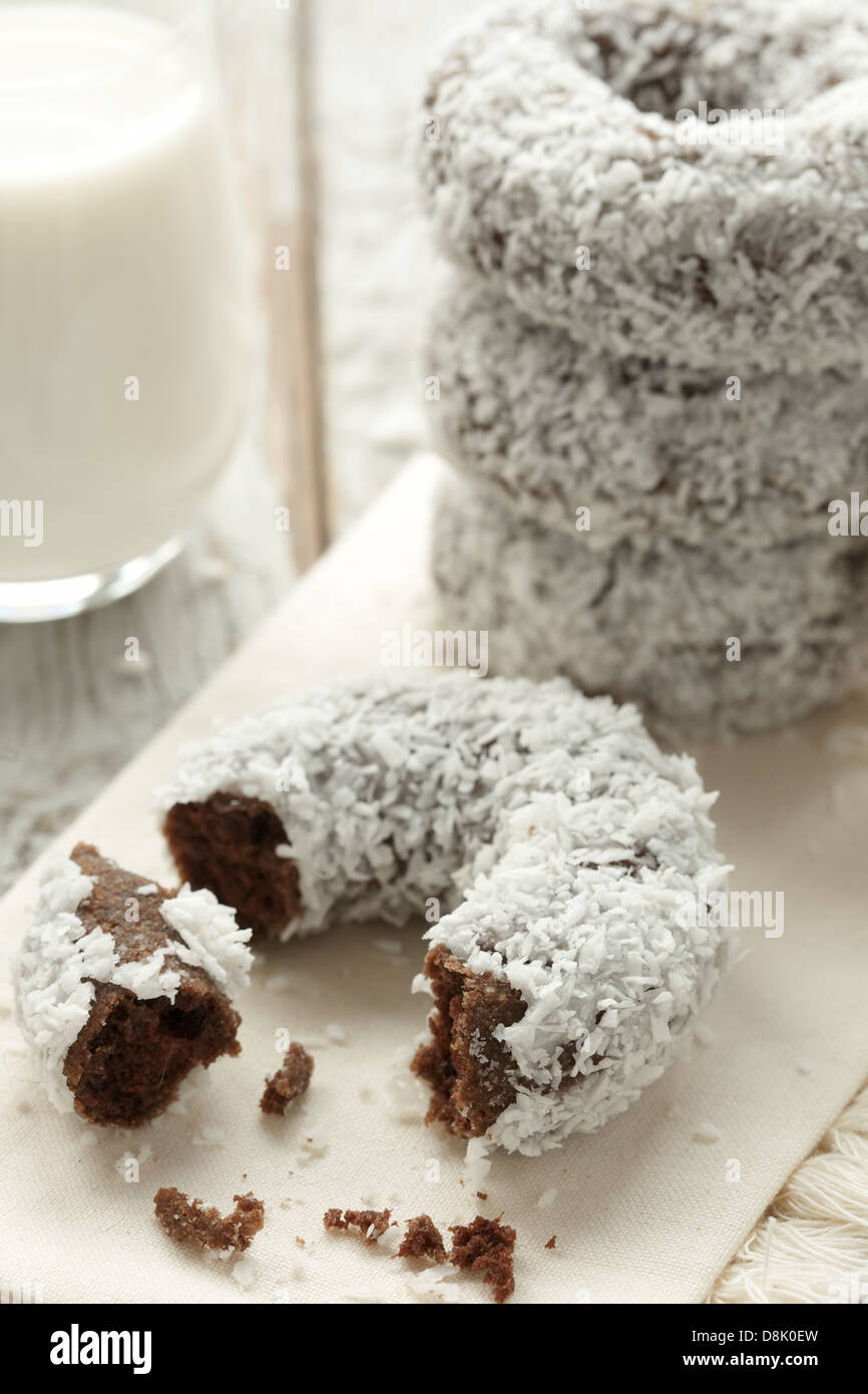 Schließen Sie herauf Bild der frisch zubereitete Schokolade Donuts bedeckt mit Kokosflocken Stockfoto