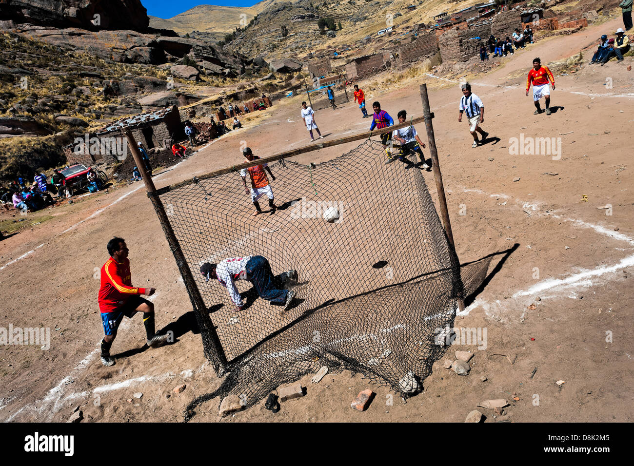 Einheimische Männer spielen Fußball auf einem Fußballplatz Schmutz in die ländliche Berggemeinde in der Nähe von Puno, Peru. Stockfoto