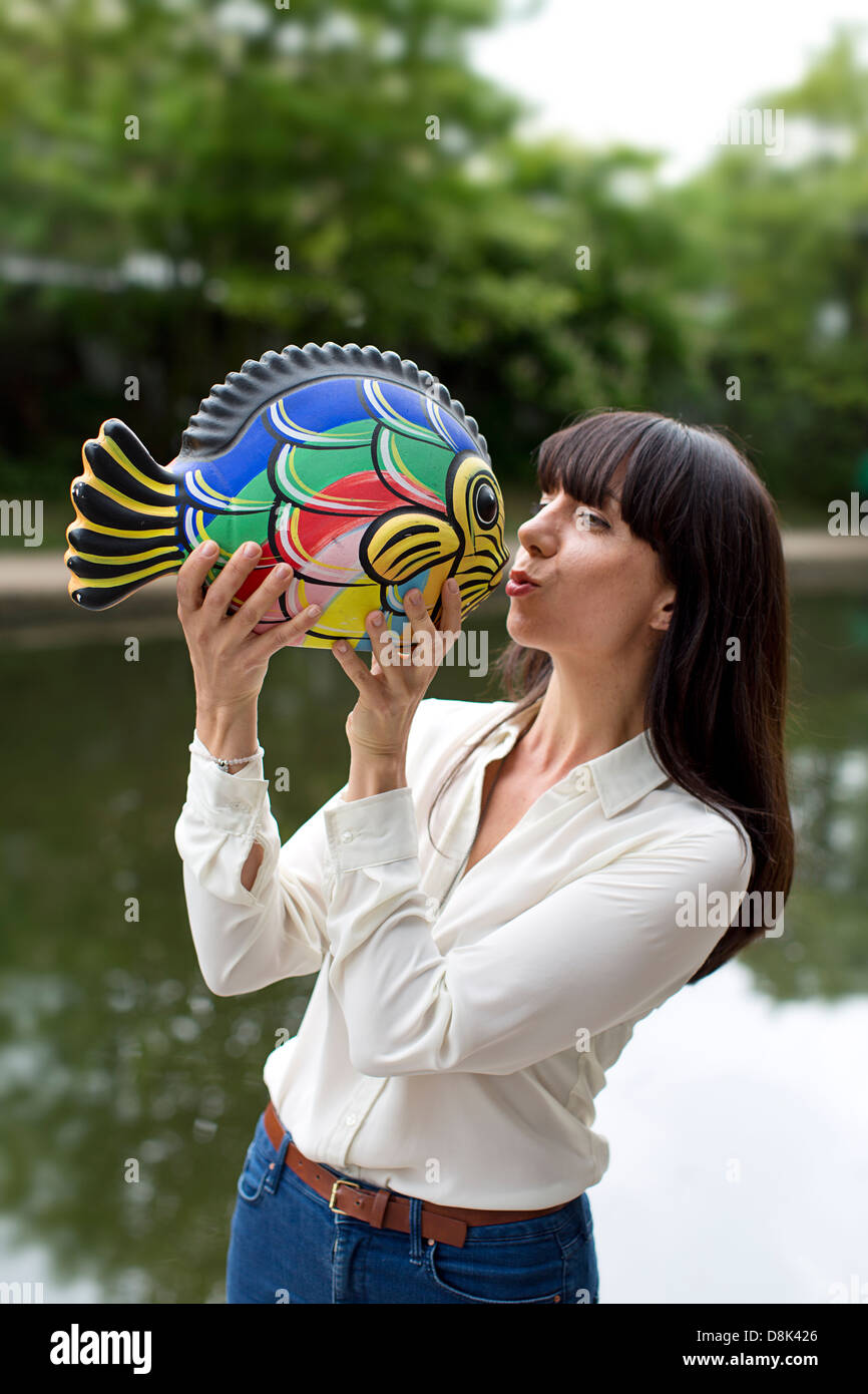 Ein Mädchen mit einem Keramik Fisch Stockfoto