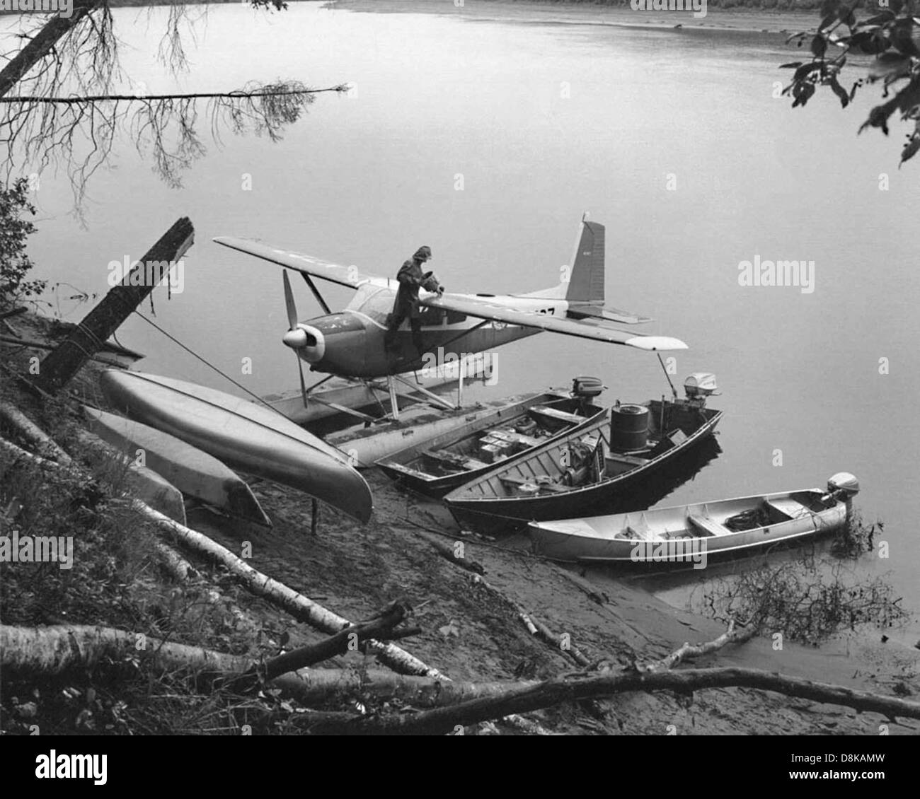 Vintage Foto Mann auf und Wasserflugzeug am Ufer mit kleinen Booten. Stockfoto