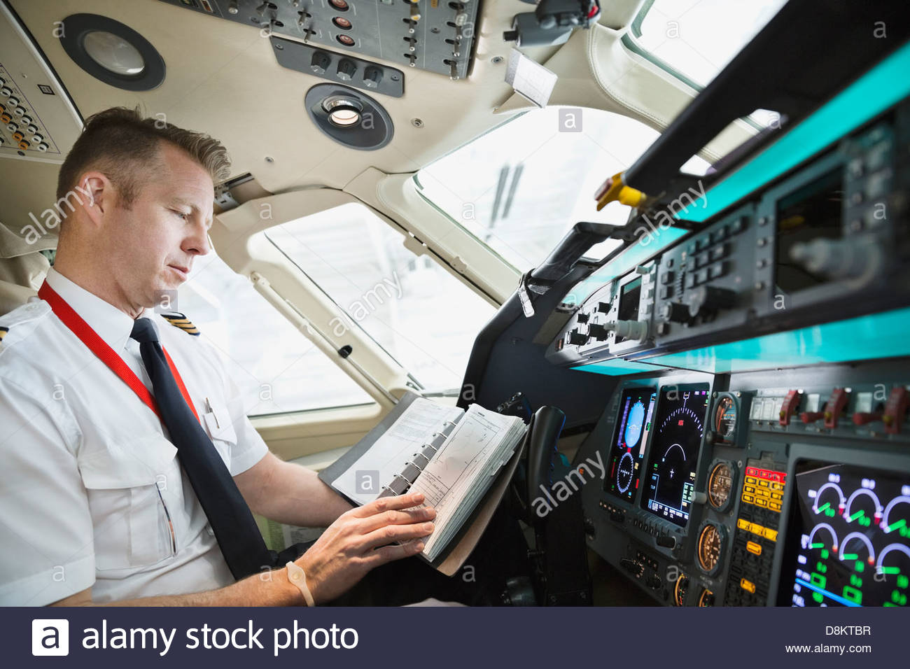 Männliche Piloten Check-Logbuch im Flugzeug-cockpit Stockfoto