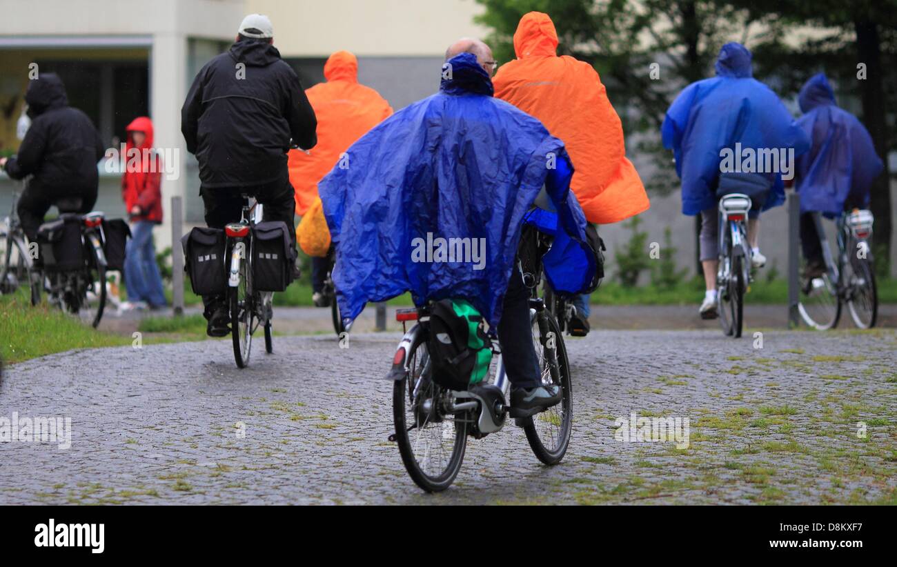 Fahrradfahrer schützen sich vor dem Regen mit Regenponchos in Freyburg, Deutschland, 30. Mai 2013. Unwetter-Uhren sind nach wie vor in Sachsen-Anhalt, Sachsen und Thüringen erwartet. FOTO: JENS WOLF Stockfoto