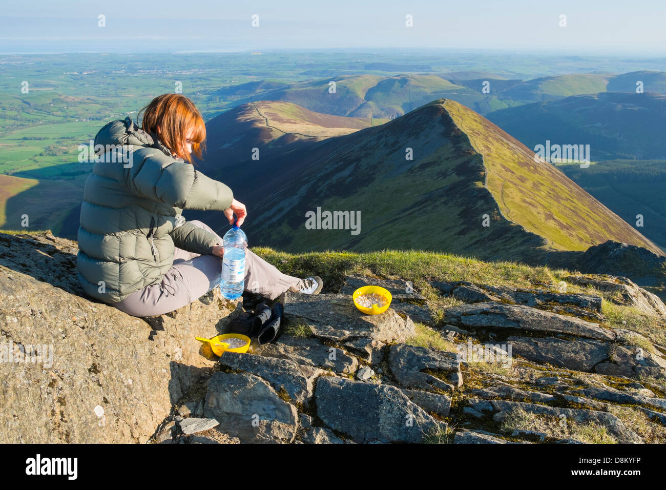 Ein Wanderer, die Zubereitung des Frühstücks auf dem Gipfel des Hopegill Head bei Sonnenaufgang im Lake District Stockfoto