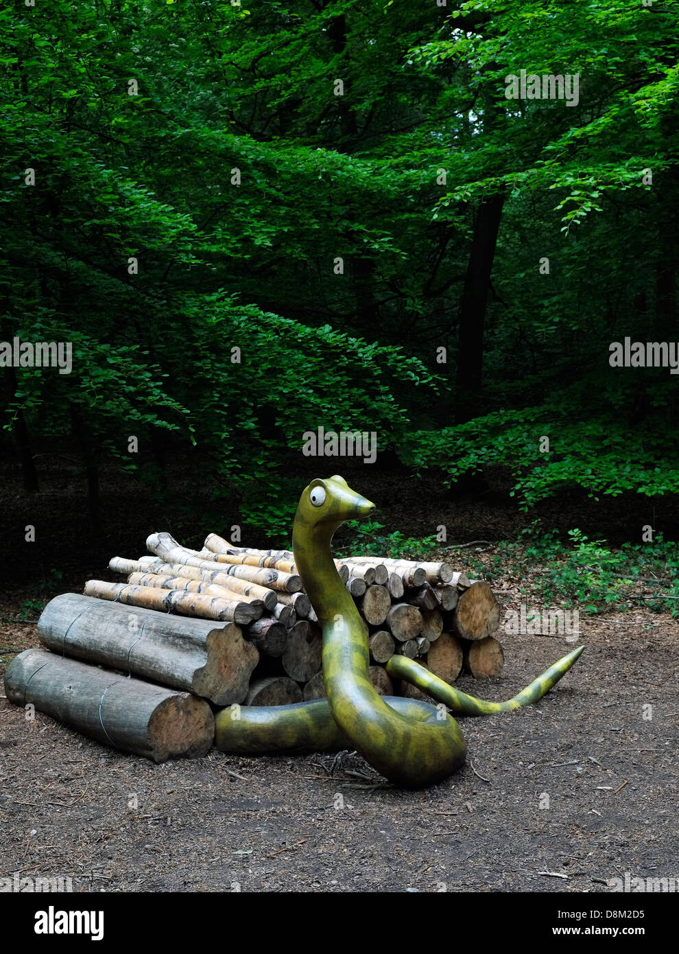 Eine hölzerne Skulptur einer Schlange aus einem Haufen von Protokollen. Stockfoto