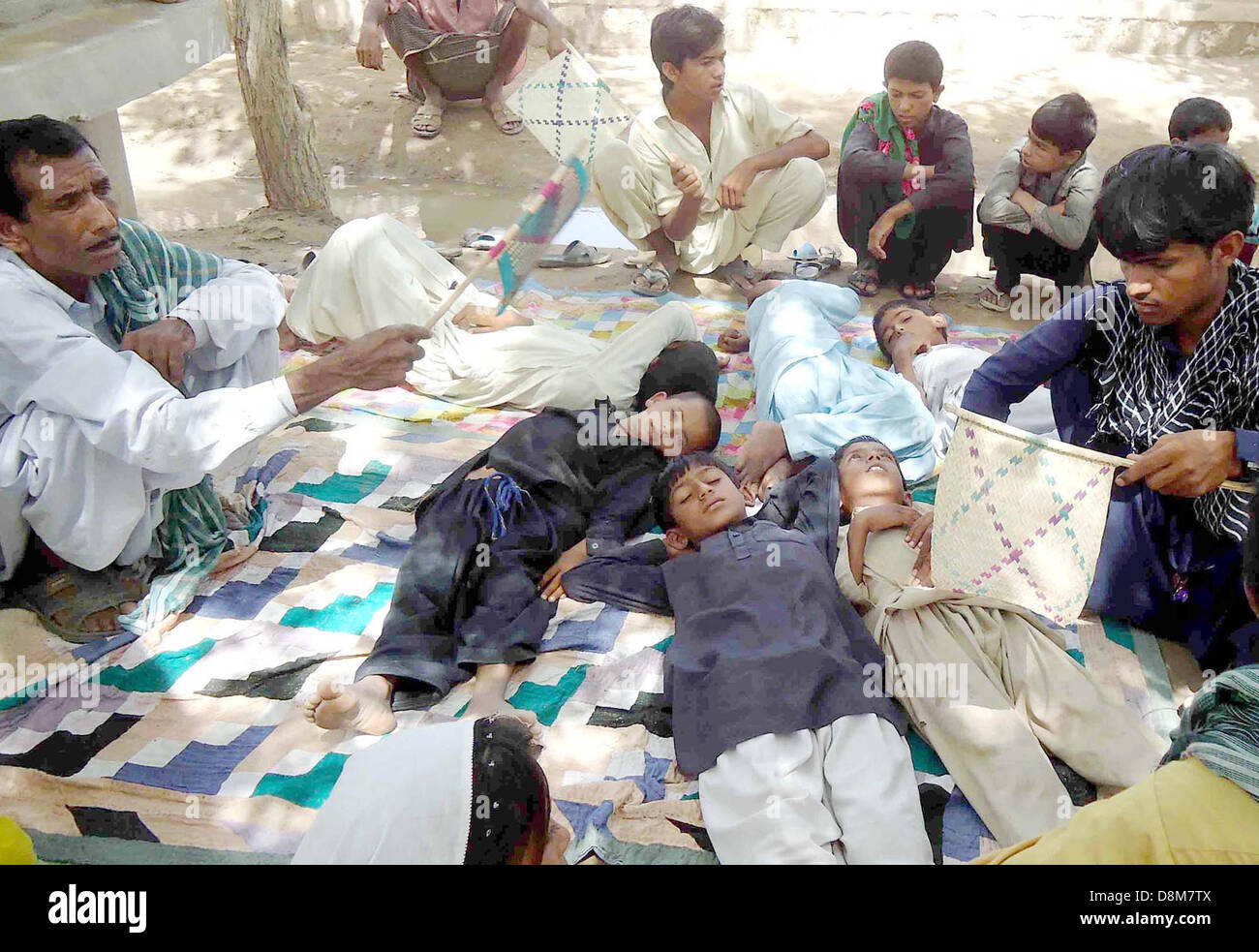 Kinder, die unreines vergiftetes Wasser in einer Schule trinken sind am Hof in Sualehpat Lokalität in Sukkur auf Freitag, 31. Mai 2013 liegen. Stockfoto