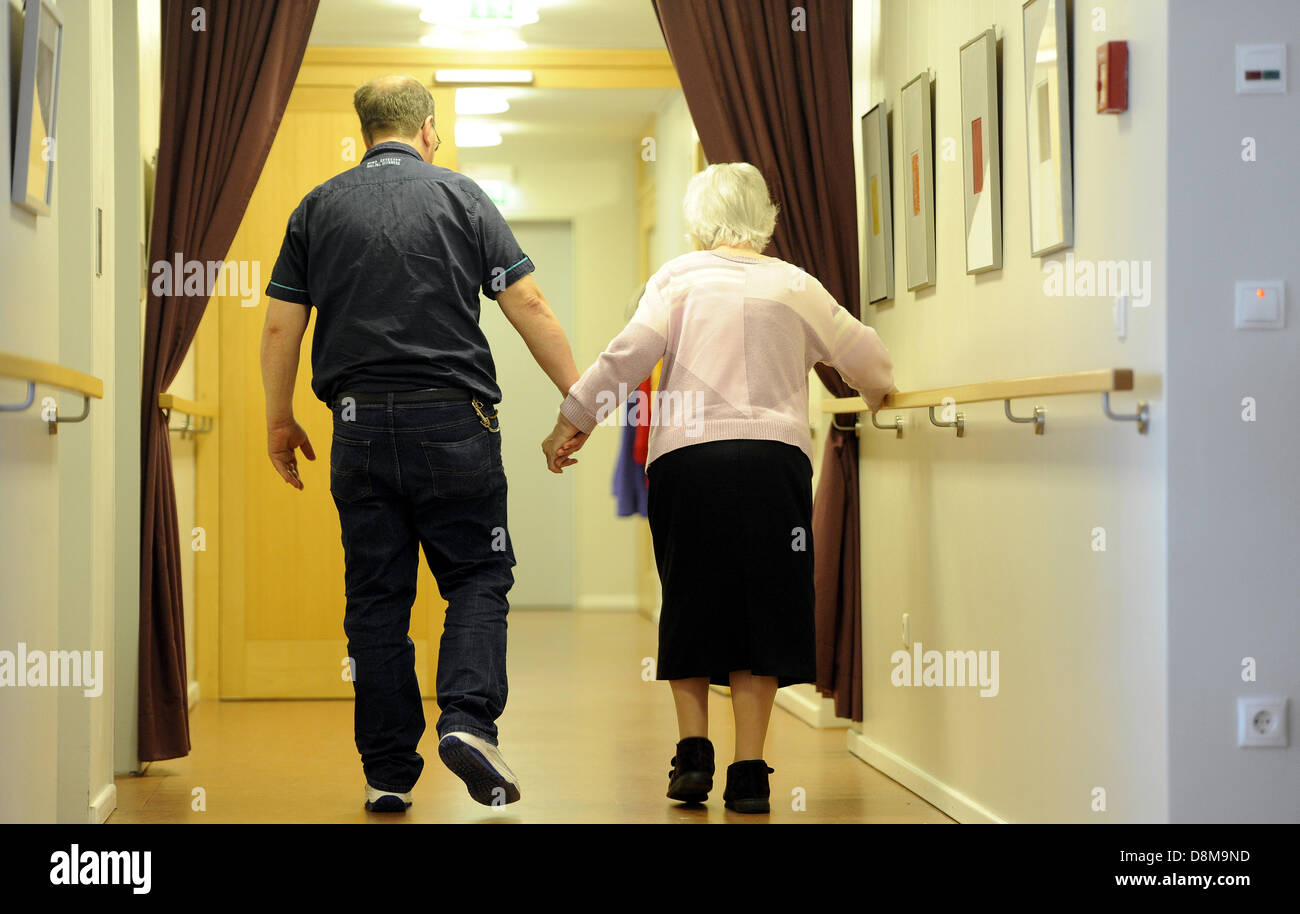 Siegfried Bednors geht auf einen Flur mit Gerda Janneck im Haus für Menschen mit Demenz. Der geistig Behinderte Mann ist eine gute Seele für den kranken Menschen in das "Haus im Park" in Bremerhaven (Bremen), Deutschland. Stockfoto