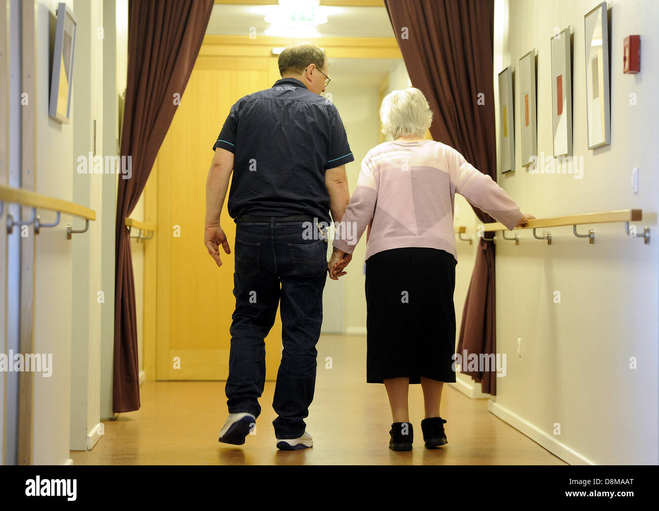 Siegfried Bednors geht auf einen Flur mit Gerda Janneck im Haus für Menschen mit Demenz. Der geistig Behinderte Mann ist eine gute Seele für den kranken Menschen in das "Haus im Park" in Bremerhaven (Bremen), Deutschland. Stockfoto