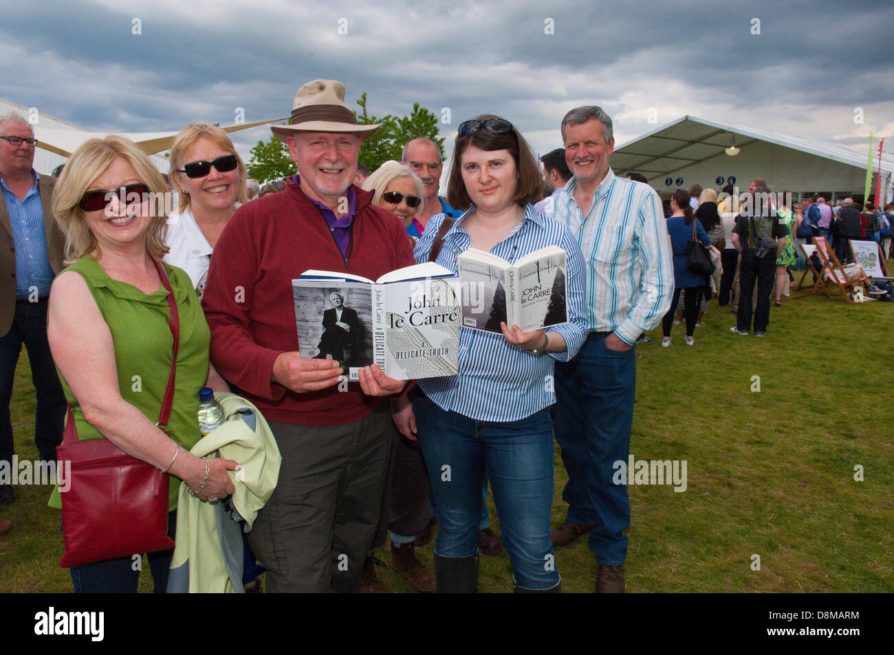 Hay-on-Wye, UK. 31. Mai 2013. David Blair 64, (Mitte mit Hut) ein Berater hat mit Freunden aus Belfast für die Le Carre Veranstaltung kommen.  Le Carré Fans bilden eine riesige Schlange unter einem ominösen Himmel zu ihrem Buch signiert. John Le Carré, der Schöpfer von George Smiley und Autor von vielen Spion Meisterwerke, sprach über seine Arbeit in einem Doppel-Länge Interview mit Philippe Sand bei seinem ersten Besuch in The Hay-Festival. Sein neue Roman ein zarte Wahrheit erfolgt am 25 April. Photo Credit: Graham M. Lawrence/Alamy Live-Nachrichten. Stockfoto