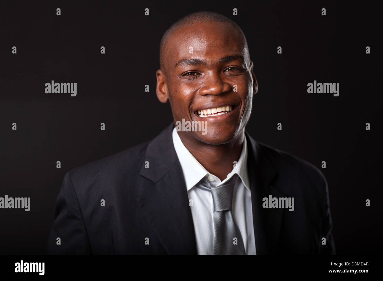 hübscher junger afrikanischer Geschäftsmann auf schwarzem Hintergrund Stockfoto