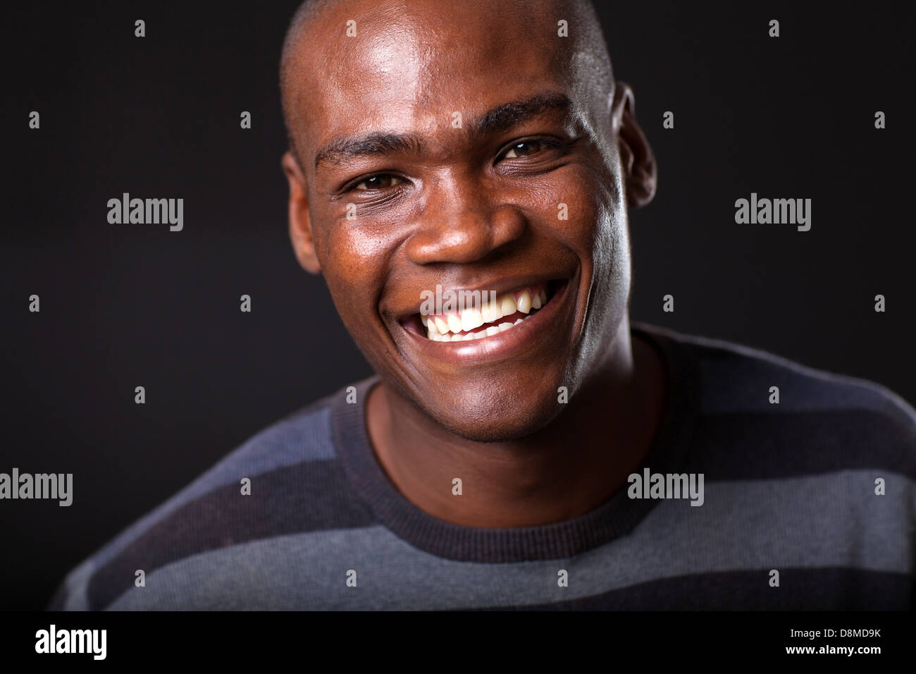 hübscher junger afrikanischer Amerikaner Mann auf schwarzem Hintergrund Stockfoto