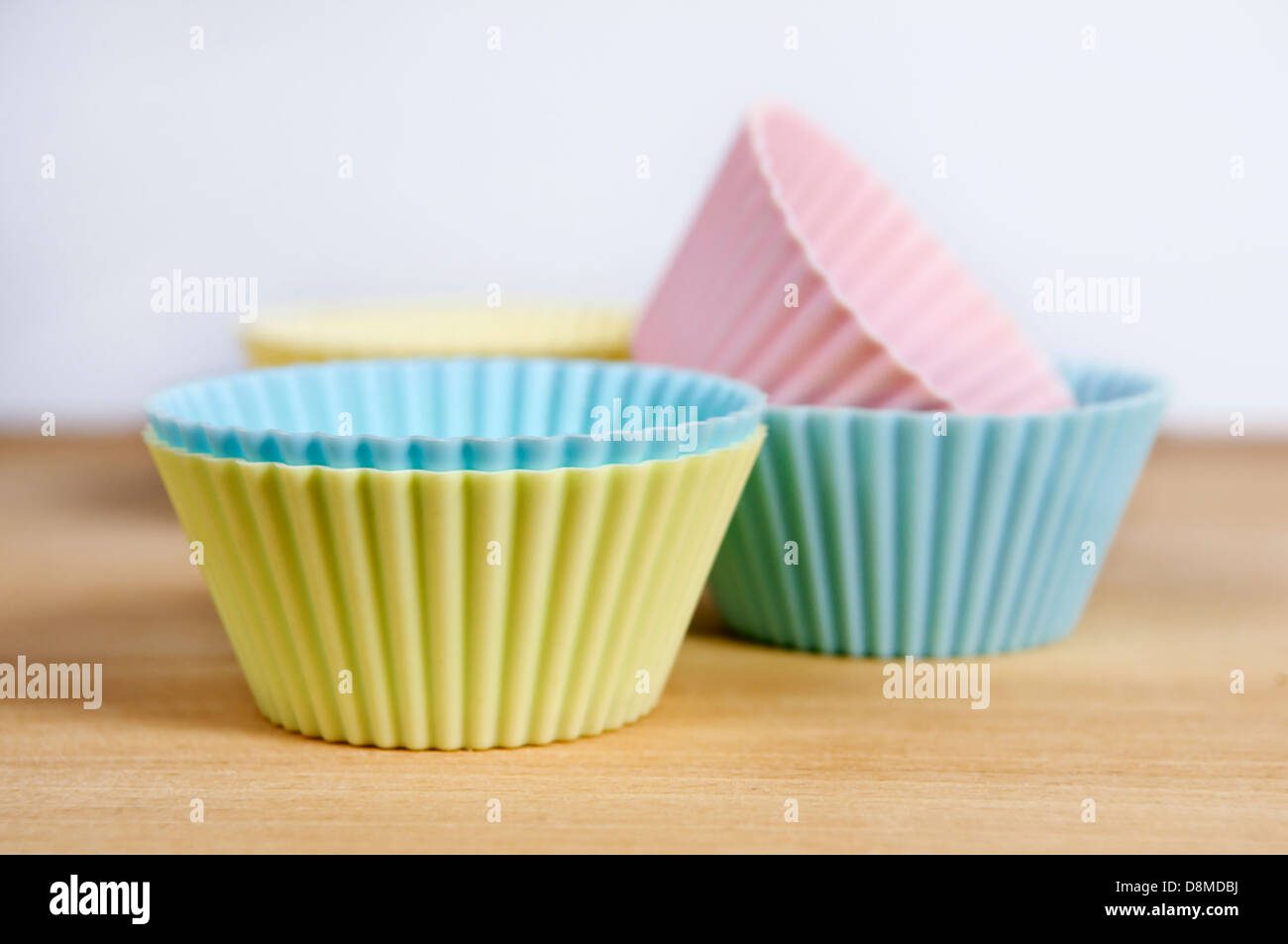 Silikon Muffin Fällen mit Lebensmittelfarbe auf Schneidbrett aus Holz Stockfoto