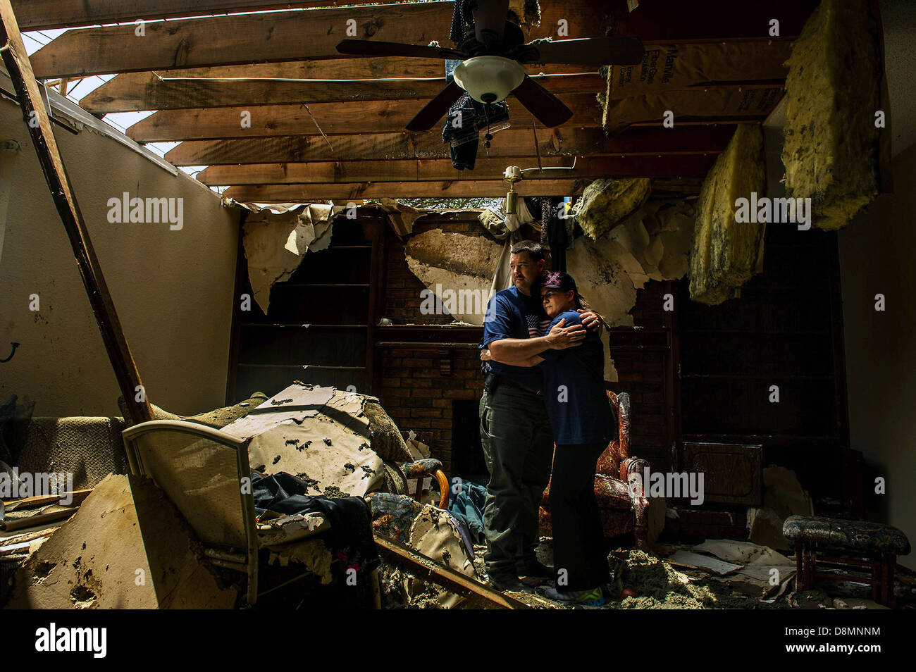US Air Force Tech SGT Rhonda Stockstill umarmt Mann Lendle Stockstill 27. Mai 2013 in den zerstörten Überresten ihrer früheren Heimat, die durch eine EF-5 Tornado zerstört wurde, die durch ihre Nachbarschaft in Moore, "OK" gerissen. Die Stockstills drängten sich unter der Treppe, wie der Sturm ihr Haus verwüstet. Sobald es bestanden, beeilte sich die Flieger, um medizinische Hilfe zu leisten, für Studenten und Dozenten, die wurden verletzt und gefangen im nahe gelegenen Briarwood Elementary School. Sergeant Stockstill ist eine chirurgische Techniker der 72. Medical Gruppe Tinker Air Force Base, OK zugewiesen. Stockfoto