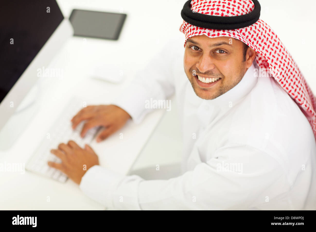 Draufsicht auf eine fröhliche arabische Geschäftsmann mit modernen computer Stockfoto