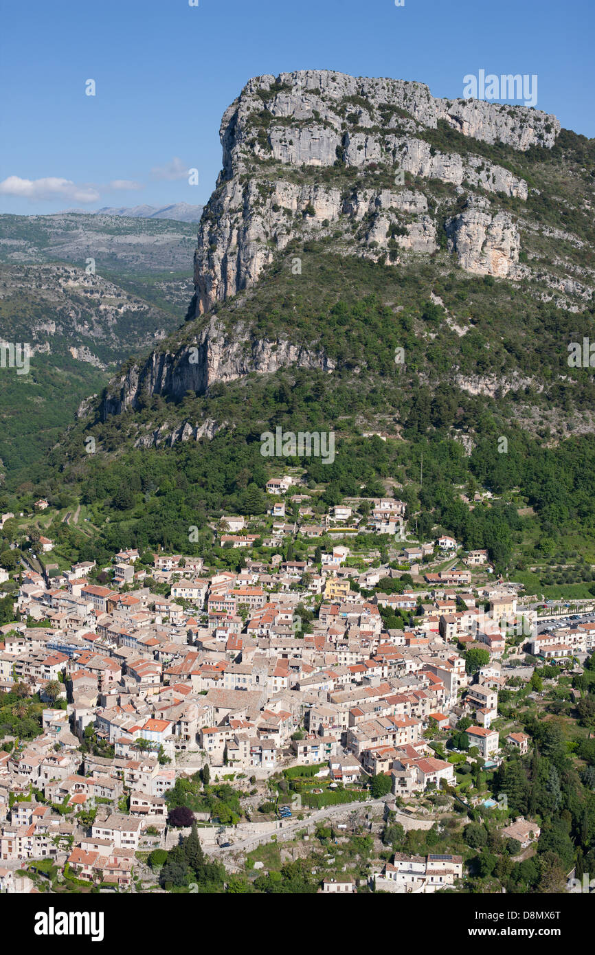 LUFTAUFNAHME. Mittelalterliches Dorf am Fuße einer massiven 400 Meter hohen Klippe. Saint-Jeannet, Französische Riviera, Alpes-Maritimes, Frankreich. Stockfoto
