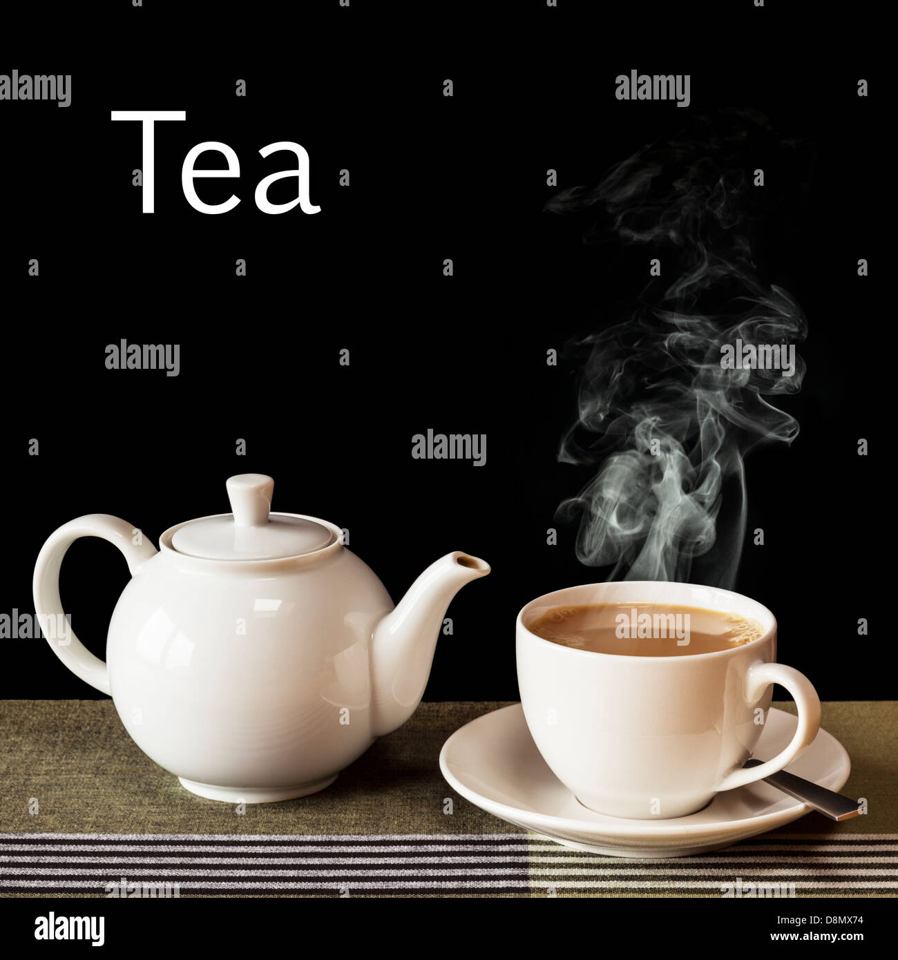 Tee-Konzept - eine heiße, dampfende Tasse Tee mit einer Teekanne auf das Wort "Tee" in weiß auf schwarzem Hintergrund. Stockfoto