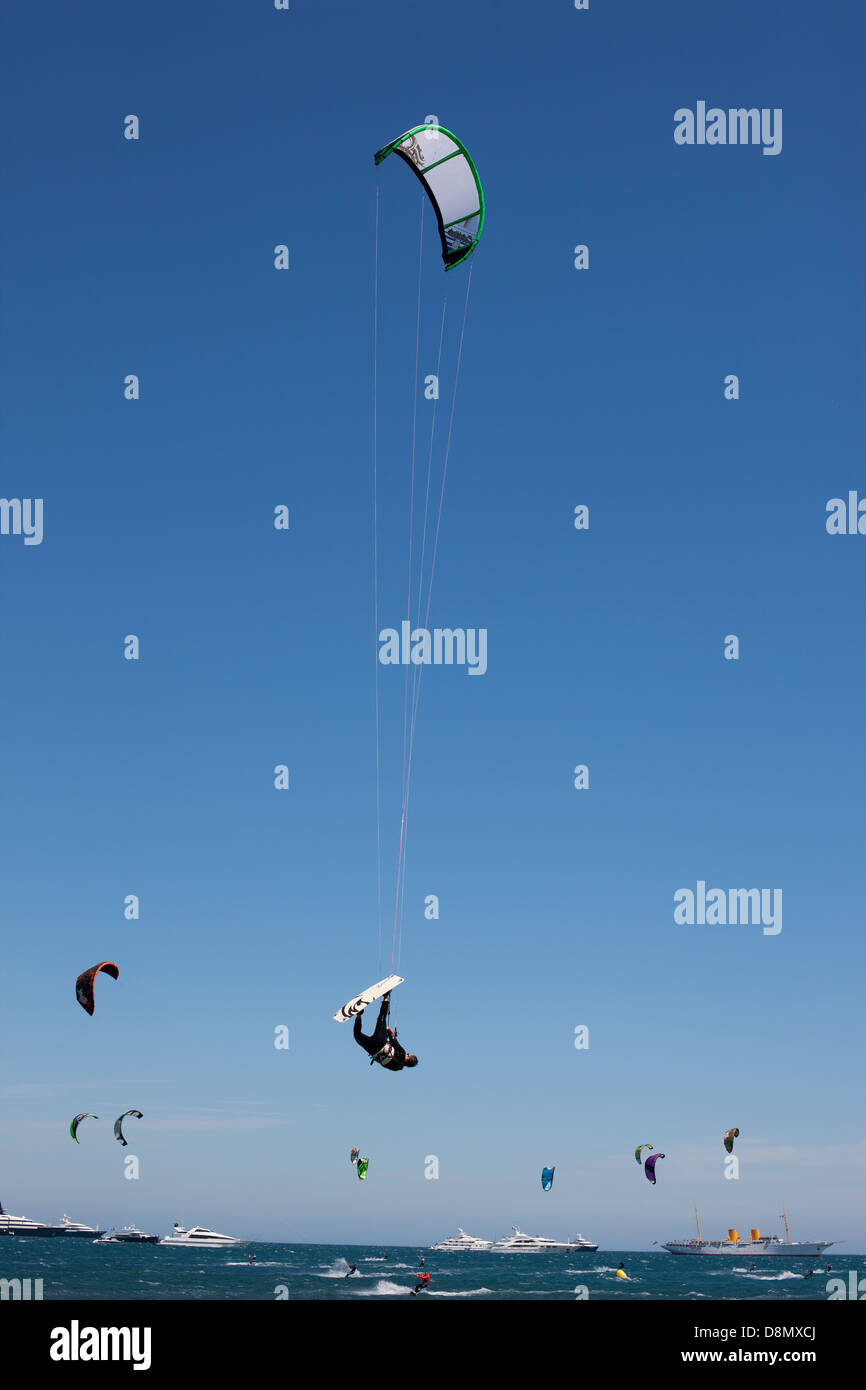 Kitesurfer fliegen hoch oben in der Luft gegen einen blauen Himmel. Cannes, Französische Riviera, Alpes-Maritimes, Frankreich. Stockfoto