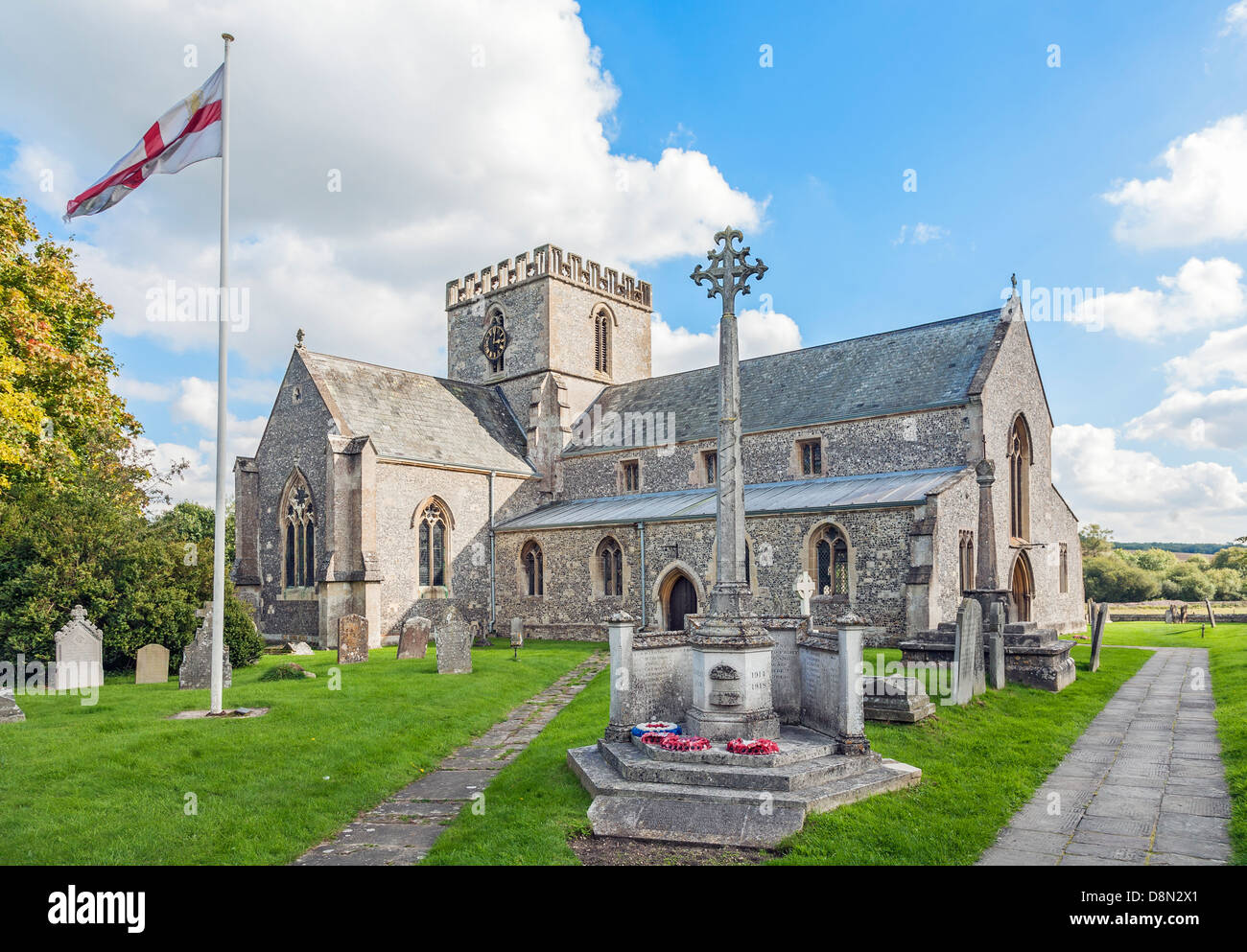 Str. Marys Kirche, großes Bedwyn, Wiltshire, England mit Flagge Pol und Krieg-Denkmal im Sommer Stockfoto