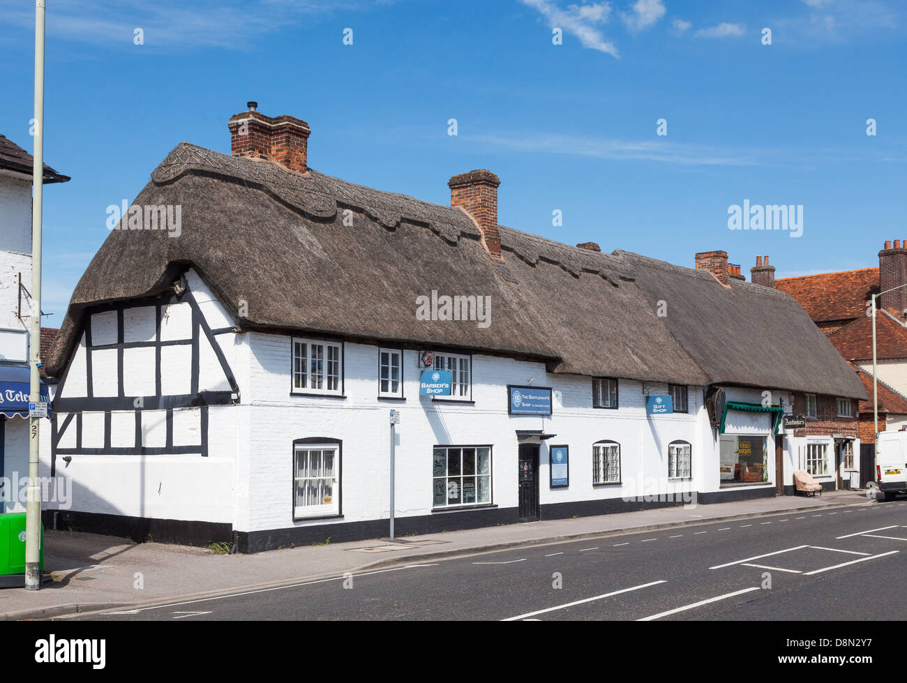 Weißen reetgedeckten Gebäude als Geschäfte in Hungerford, Berkshire, England, einschließlich einen Friseurladen Stockfoto