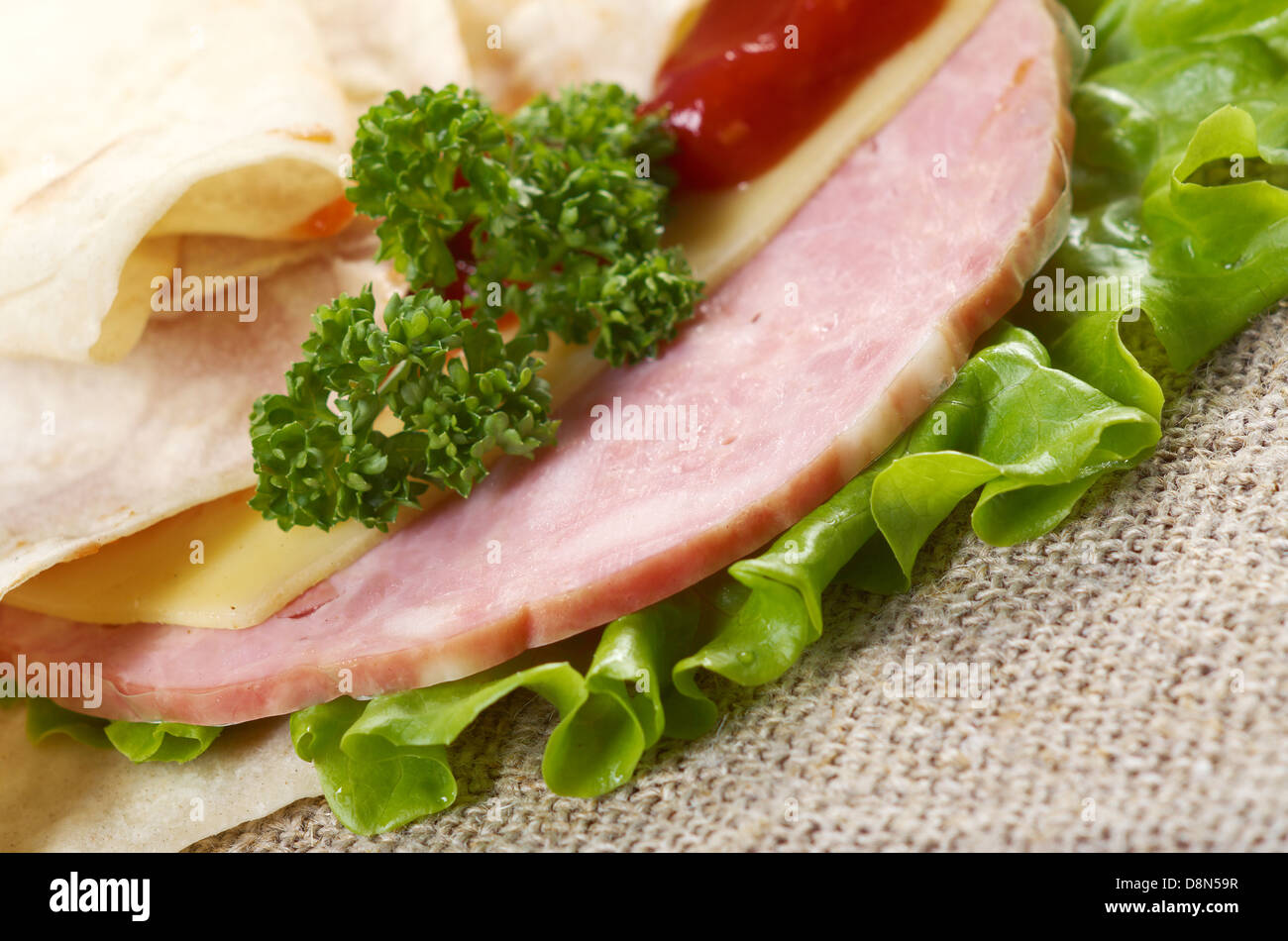 Fladenbrot-Sandwich mit Käse, Schinken, Petersilie und Tomatensauce Stockfoto