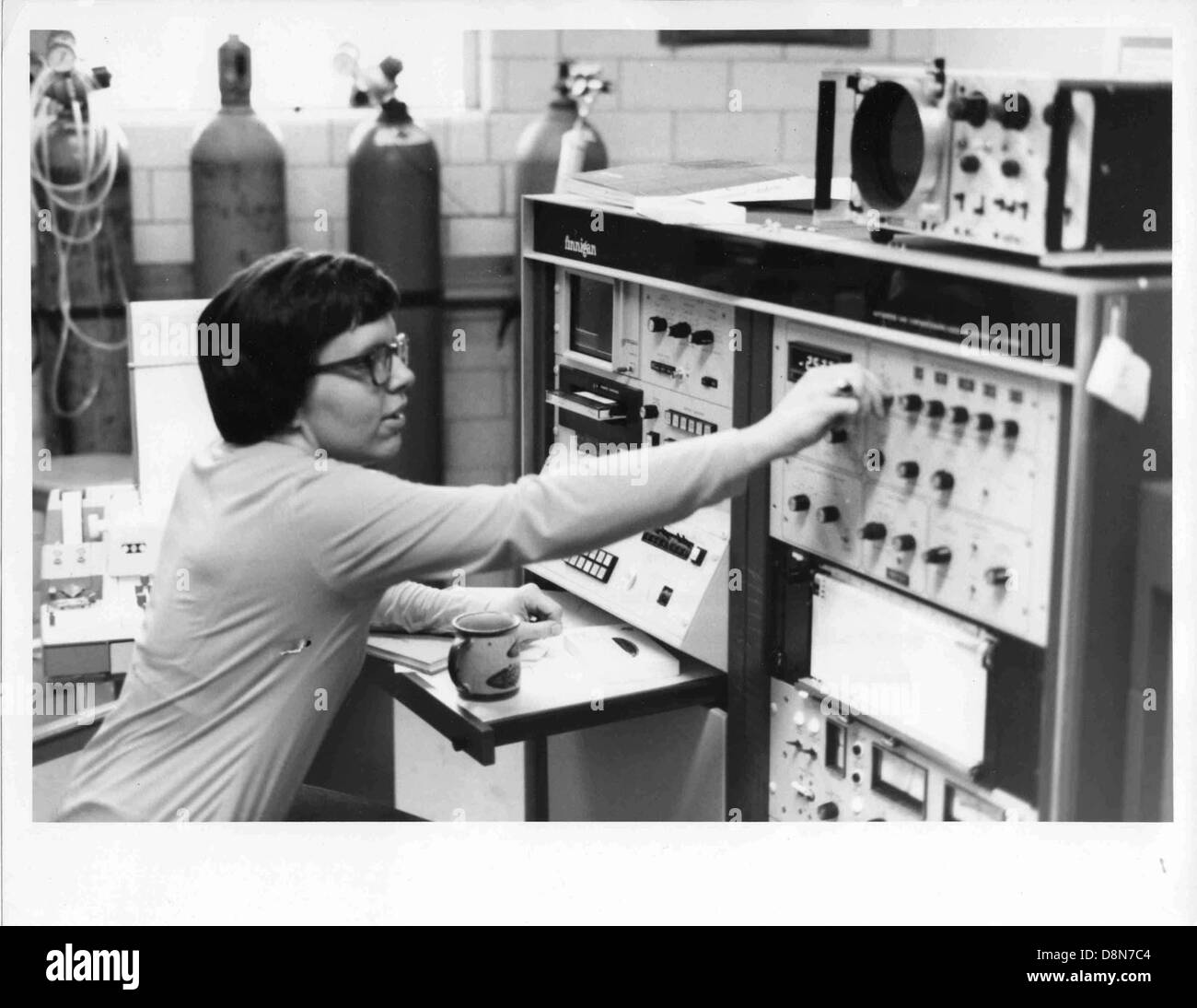 Ein fokussiertes Bild einer Wissenschaftlerin, die einen Gaschromatographen, ein Laborgerät zur Analyse von Verbindungen, betreibt. Das Foto zeigt ihr Engagement in der wissenschaftlichen Forschung und den technischen Charakter des Prozesses. Stockfoto