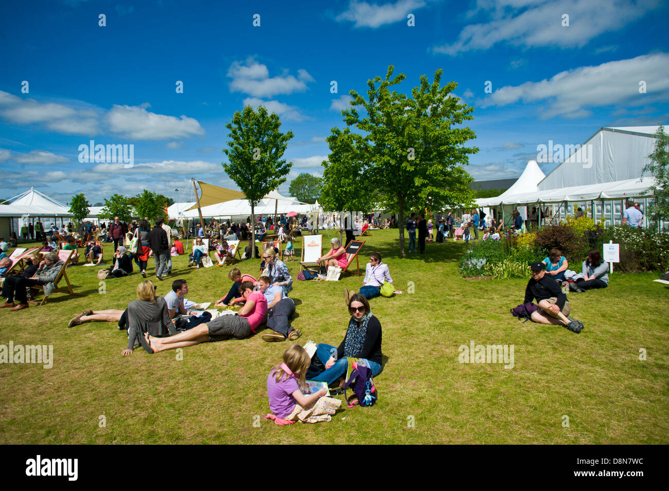 Besucher genießen die warmen Sommer Wetter entspannen auf dem Rasen im Hay Festival 2013 Hay on Wye Powys Wales UK Stockfoto