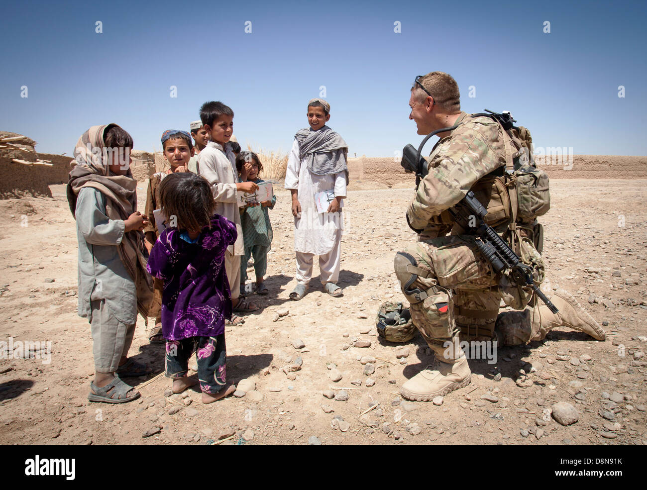 US Army Staff Sgt Matthew Parsons mit der Polizei Berater Team Delaram spricht mit afghanischen Kindern 26. Mai 2013 in Delaram, Provinz Helmand, Afghanistan. Stockfoto