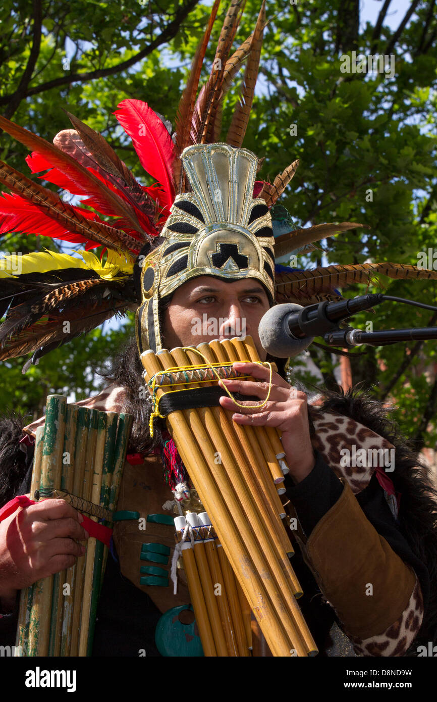 Manchester, Großbritannien. 1. Juni 2013. Sergio Fistely (MR) eine Straße Entertainer in Aztec Indianer Indianer Kostüm und Federkopfschmuck in Manchester Piccadilly genießen Sie die vielfältigen Attraktionen der Innenstadt mit peruanischer Straßenmusikanten, kostümierte street Musiker, spielen für die musikalische Begleitung. Panflöten, Panflöte, Syrinx, Flöte sind eine Gruppe von Musikinstrumente auf das Prinzip der geschlossenen Röhre, bestehend aus mehreren Leitungen nach und nach Länge erhöhen. Mehrere Sorten von Panflöten schon lange beliebt wie Folk Instrumente. Der hölzerne Rohrleitungen werden in der Regel aus Bambus, oder Zuckerrohr hergestellt. Stockfoto
