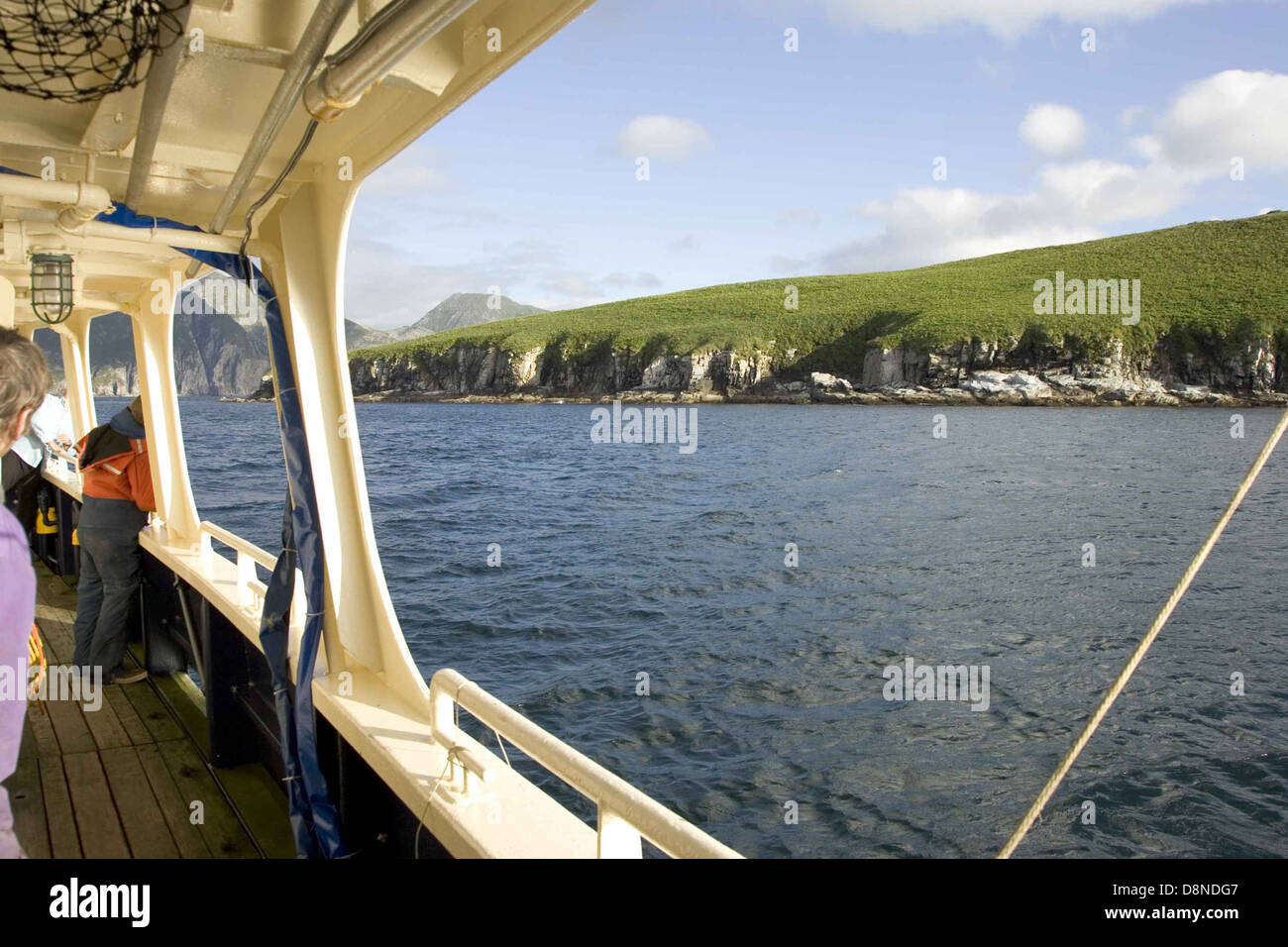 Eine malerische Aussicht von einem Schiff aus, das auf die Küste blickt. Das Wasser ist ruhig, mit klarem blauem Himmel darüber. Dieses Bild hebt die Weite des Meeres und die Nähe des Landes hervor, während das Schiff auf die Küste zufährt. Stockfoto
