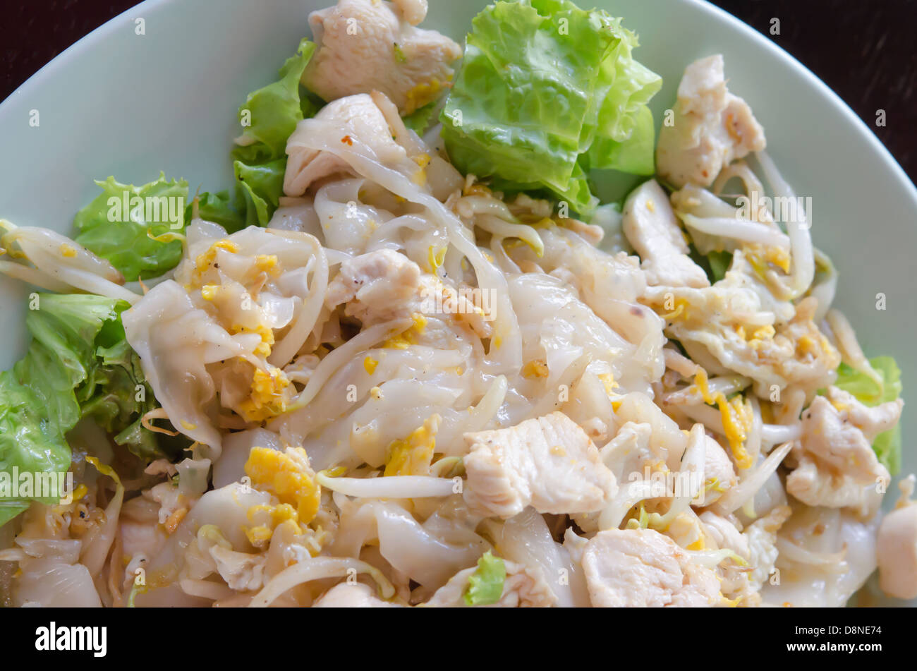 Draufsicht gebratene Nudeln mit Huhn und Gemüse auf Teller, asiatische Küche Stockfoto