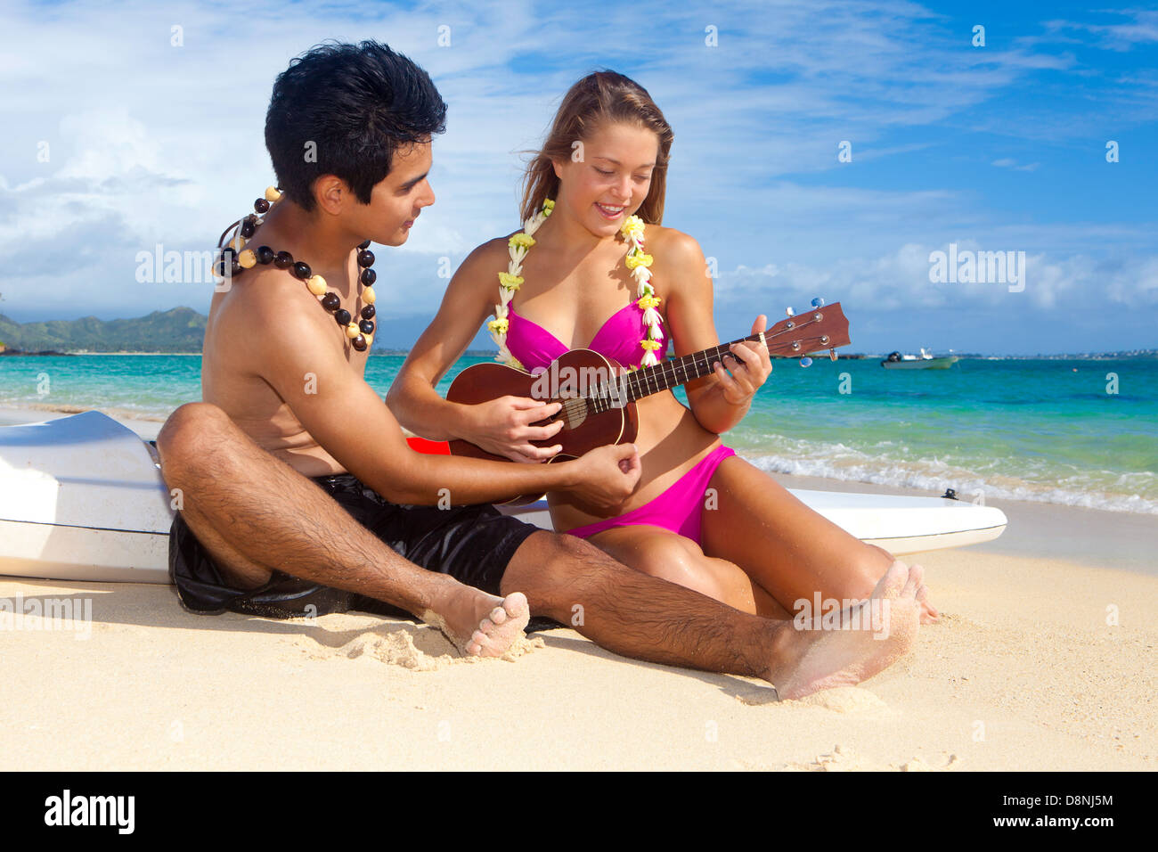 paar am Strand mit ihrem Surf Ski spielt ukulele Stockfoto