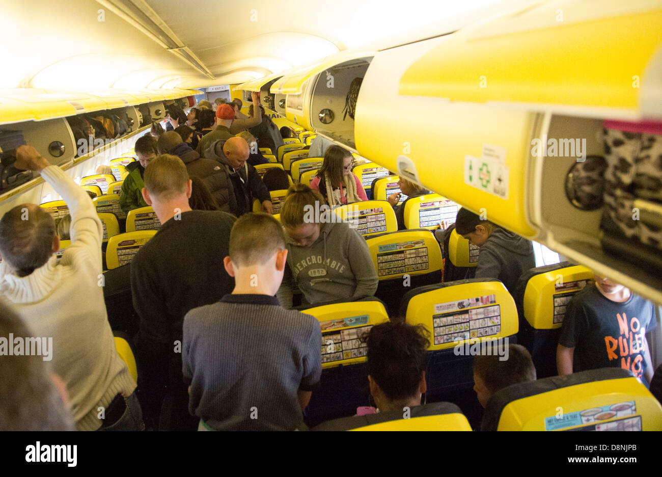 Menschen, die aufstehen nach der Landung auf Ryanair-Flug Stockfoto