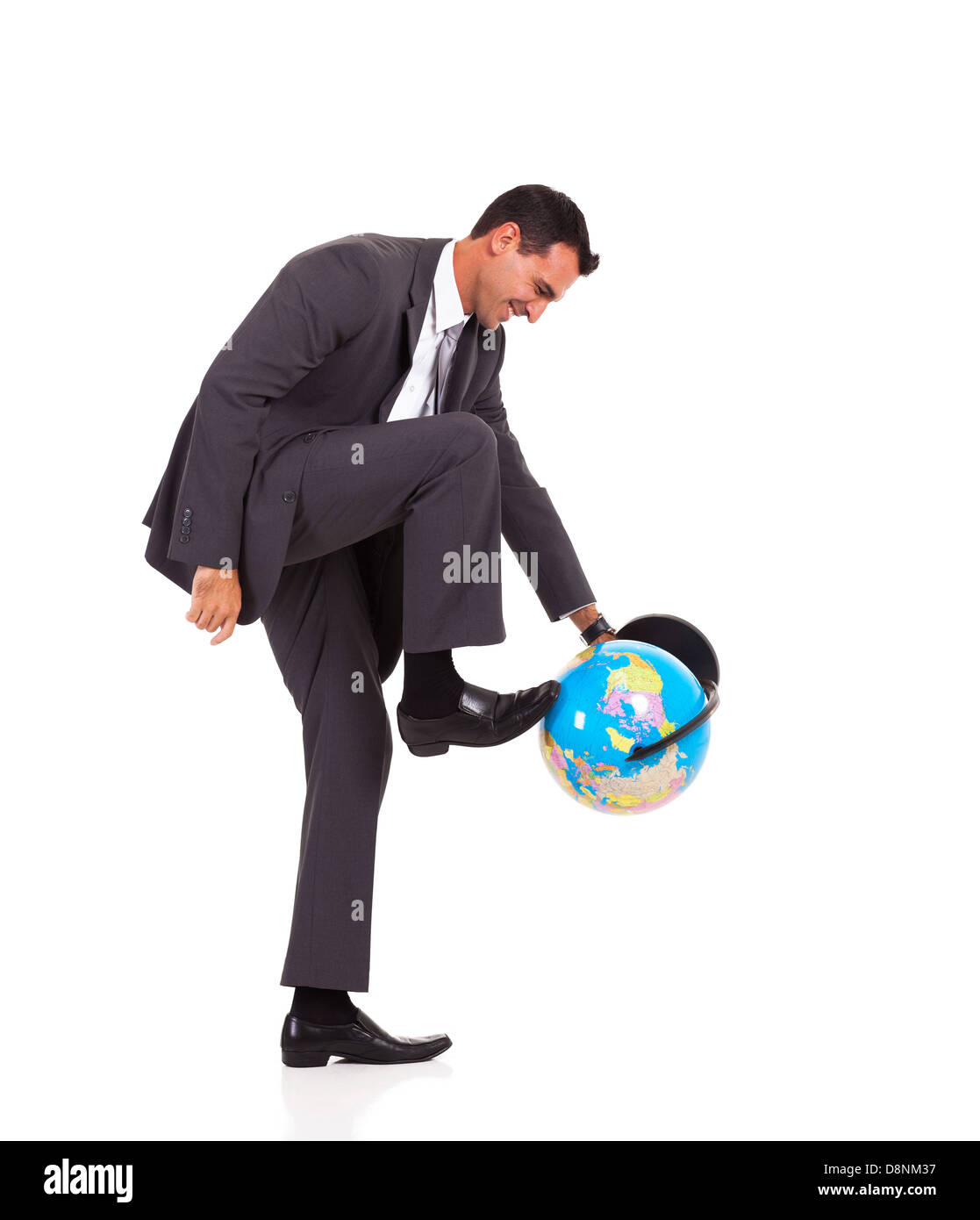 junger Geschäftsmann drehen Globus mit seinem Fuß isoliert auf weiss Stockfoto